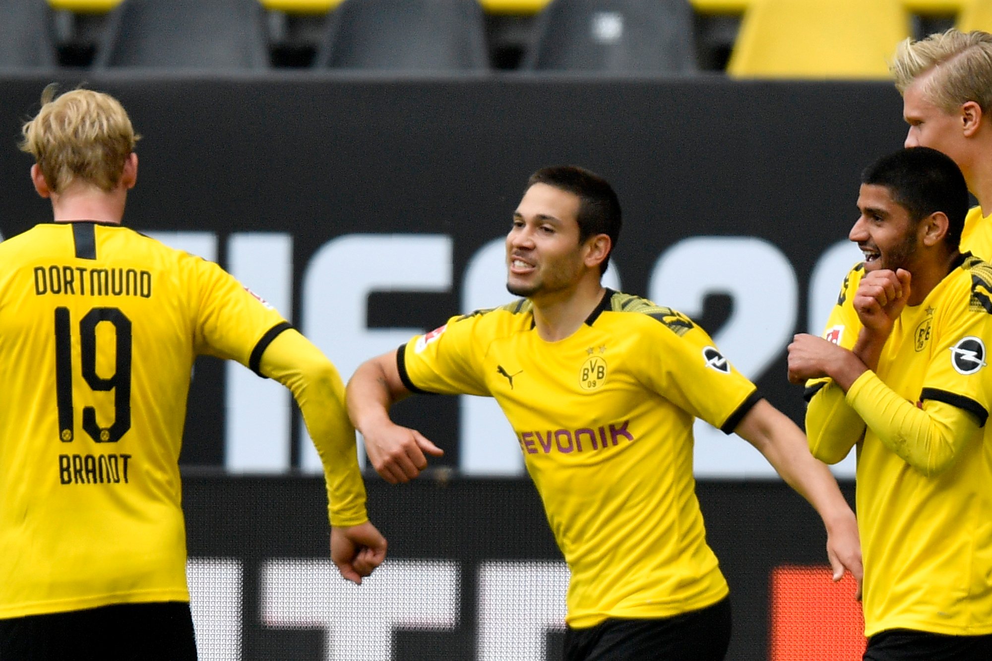 epa08426000 Dortmund&#039;s Raphael Guerreiro (C) celebrates with Julian Brandt (L) after scoring the 2-0 lead during the German Bundesliga soccer match between Borussia Dortmund and Schalke 04 in Dortmund, Germany, 16 May 2020. The German Bundesliga and Second Bundesliga are the first professional leagues to resume the season after the nationwide lockdown due to the ongoing Coronavirus (COVID-19) pandemic. All matches until the end of the season will be played behind closed doors.  EPA/MARTIN MEISSNER / POOL DFL regulations prohibit any use of photographs as image sequences and/or quasi-video.
