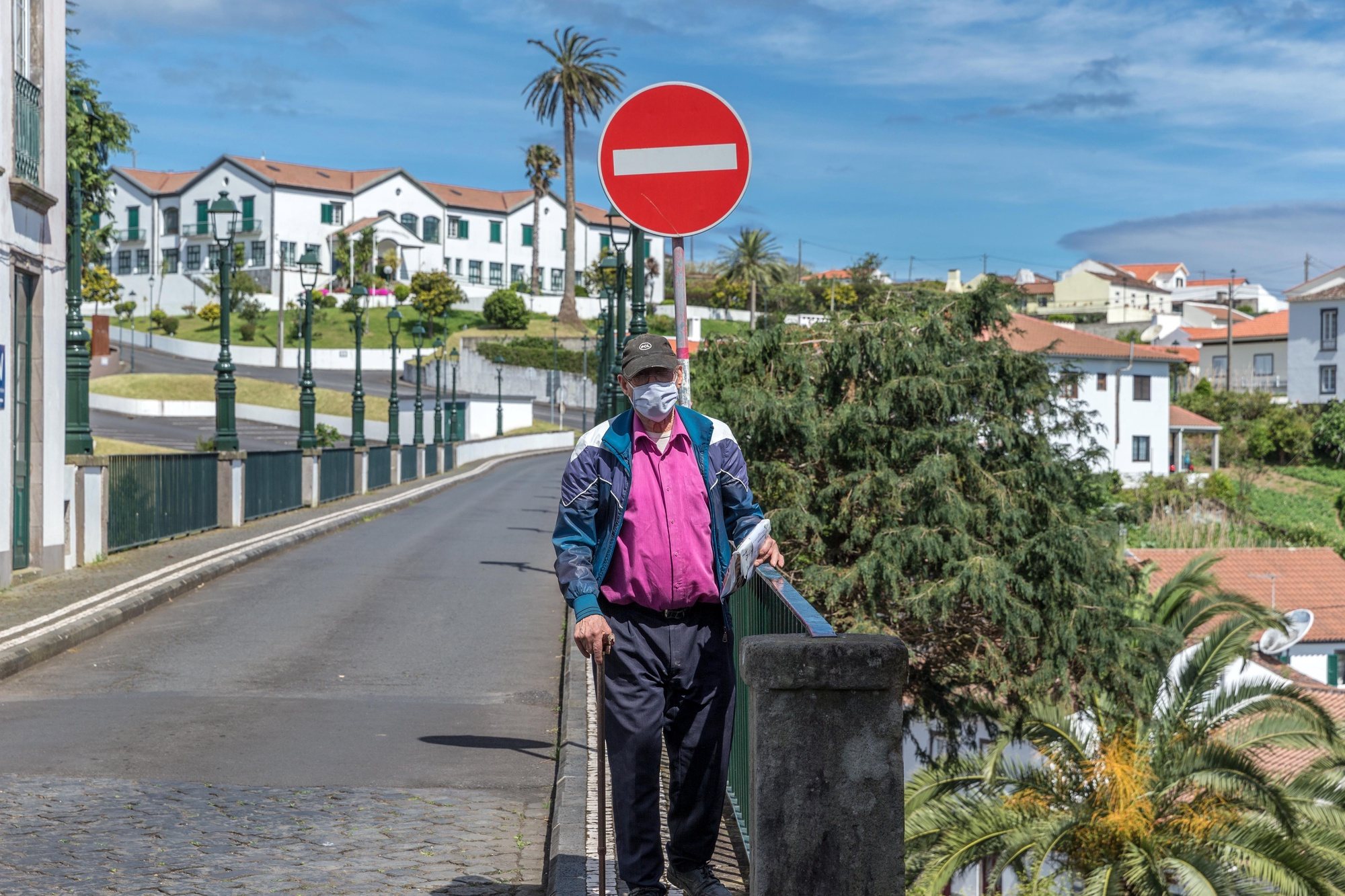 epa08430390 A man protected with a face mask walks on a street in the Nordeste municipality, Sao Miguel Island, Azores, Portugal, 18 May 2020.  The municipality of Nordeste was the last in the country to leave the sanitary fence because of the covid-19.  EPA/EDUARDO COSTA