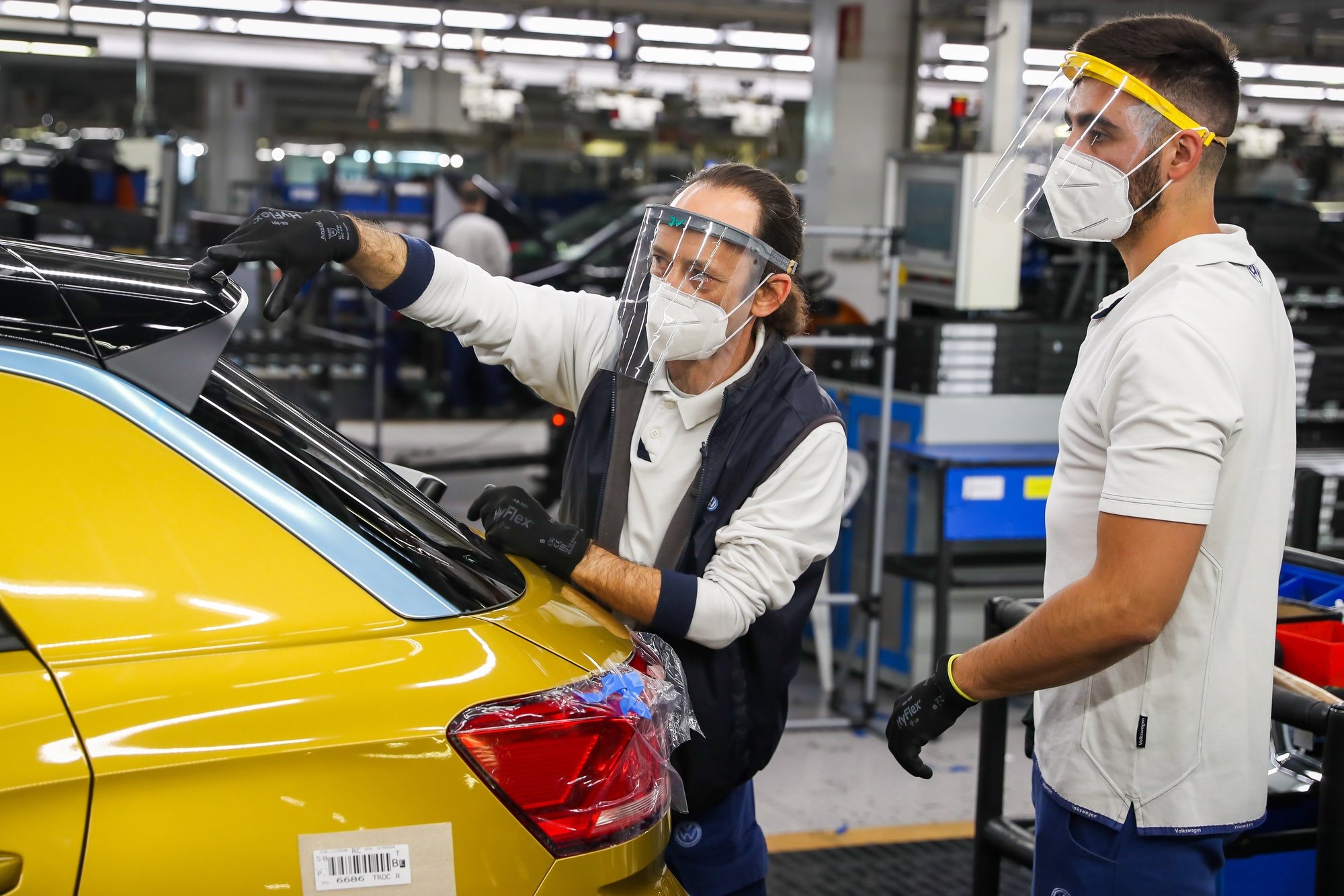 epa08419871 Autoeuropa employees work at the construction line for the Volkswagen T-Roc at Autoeuropa&#039;s plant in Palmela, Setubal, Portugal, 13 May 2020.  EPA/JOSE SENA GOULAO