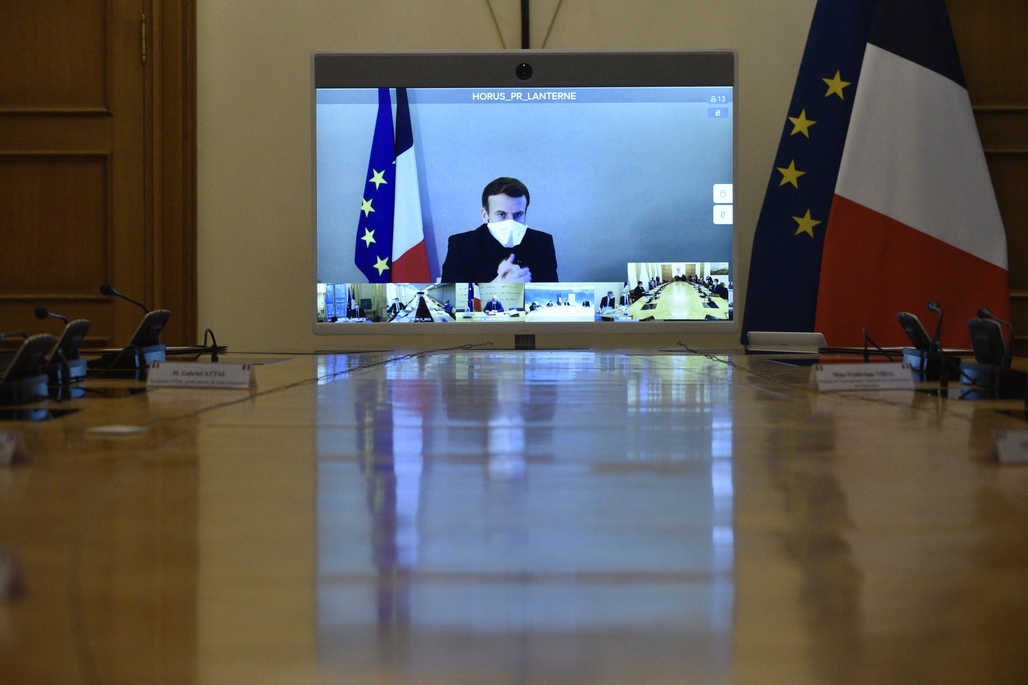 epa08897324 French President Emmanuel Macron, who tested positive for the coronavirus disease (COVID-19), is seen on a screen as he attends by video conference a round table for the weekly cabinet meeting of the government at the Army Ministry in Paris, France, 21 December 2020. According to a statement by the Elysee Palace on 17 December 2020, French President was tested positive for coronavirus Covid-19. Macron will stay in isolation in the presidential residence of &#039;La Lanterne&#039; in Versailles, but will continue to perform his duties.  EPA/JULIEN DE ROSA / POOL