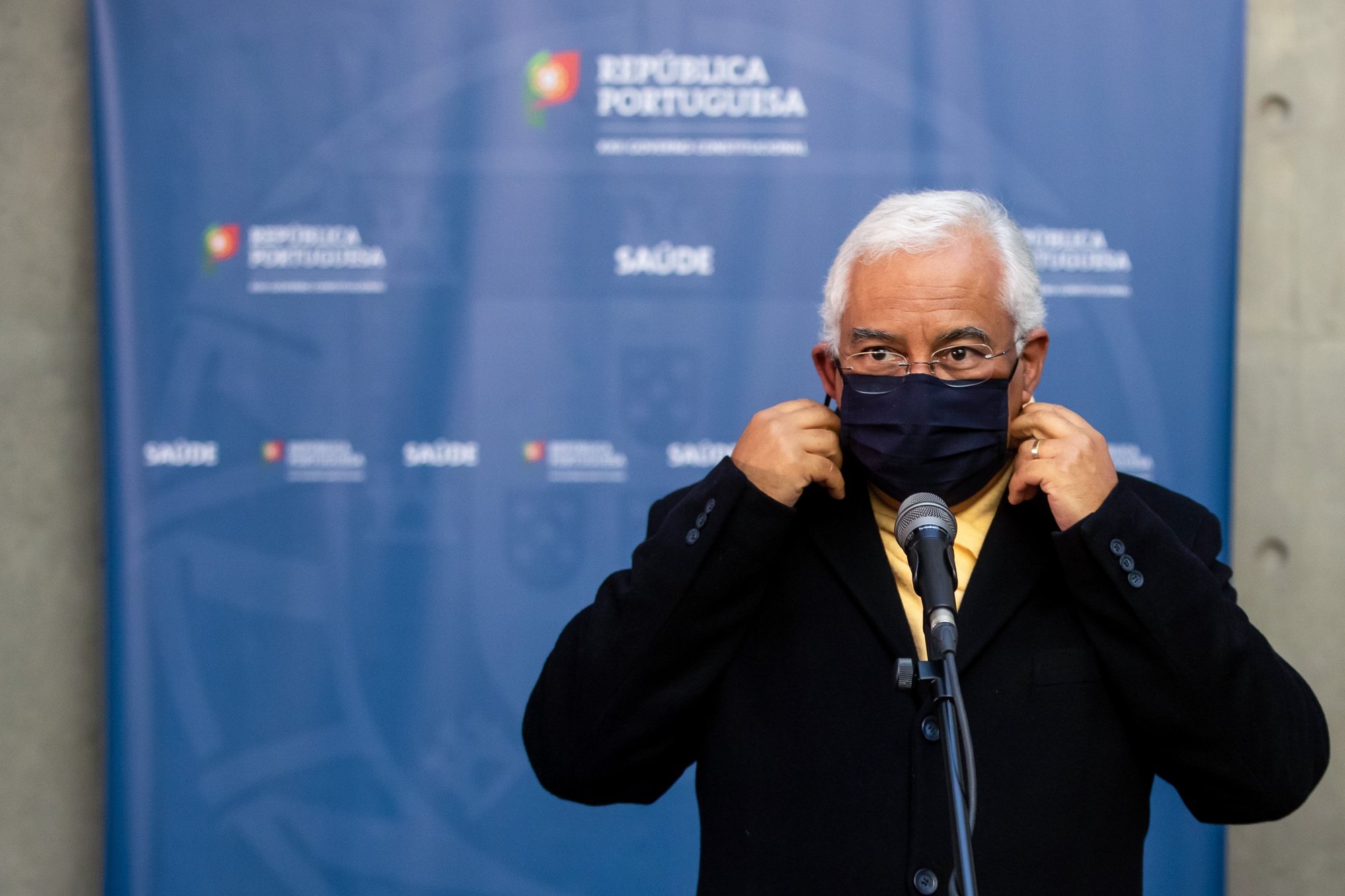 O primeiro-ministro, António Costa, retira a máscara protetora contra a Covid-19 antes de prestar declarações aos jornalistas após a 14ª sessão de apresentação da “Situação epidemiológica da Covid-19 em Portugal”, na sede do Infarmed, em Lisboa, 12 de janeiro de 2021. JOSÉ SENA GOULÃO/LUSA