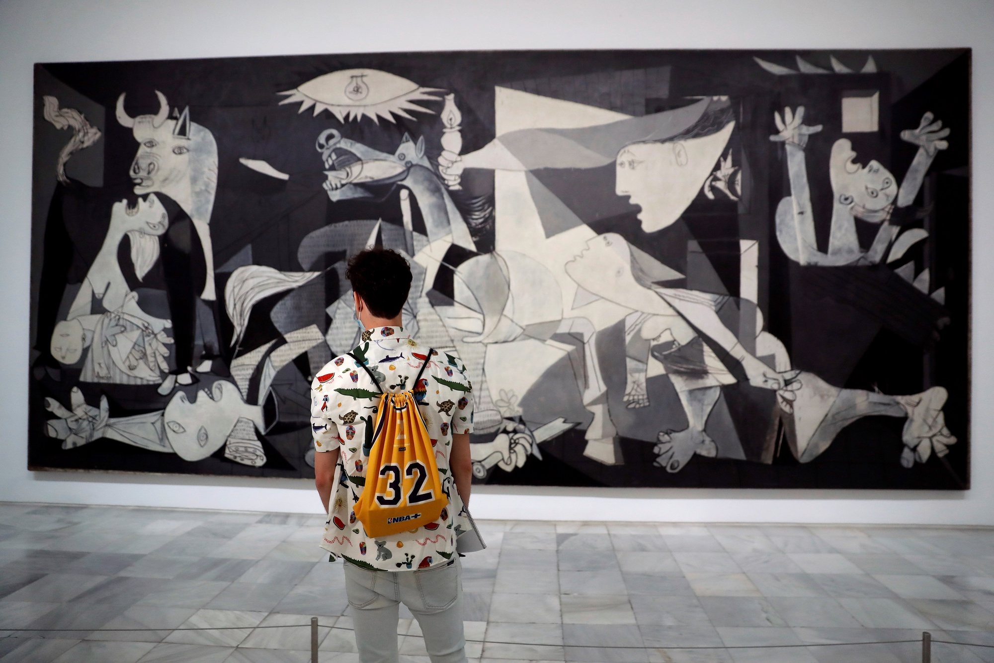 epa08462706 A man looks at Pablo Picasso&#039;s &#039;Guernica&#039; displayed at Reina Sofia Museum in Madrid, Spain, 03 June 2020. Reina Sofia Museum and many others will be reopening on 06 June in the Spanish capital with new security measures due to the coronavirus health crisis.  EPA/CHEMA MOYA
