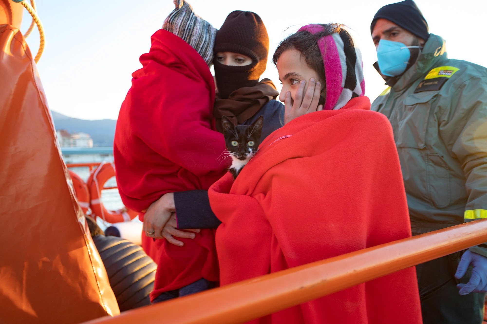 epa08945664 Two women and a minor arrive to Motril Port in Granada, Spain, with a cat after being rescued by the Spanish Maritime Rescue Services at sea, 18 January 2020. A total of 41 migrants on board three toy boats were rescued at sea as they were trying to reach the Spanish coast. A total of six toy boats have arrived to the Spanish coasts in the last hours summing up a total of 59 migrants. EFE/ Miguel Paquet  EPA/Miguel Paquet