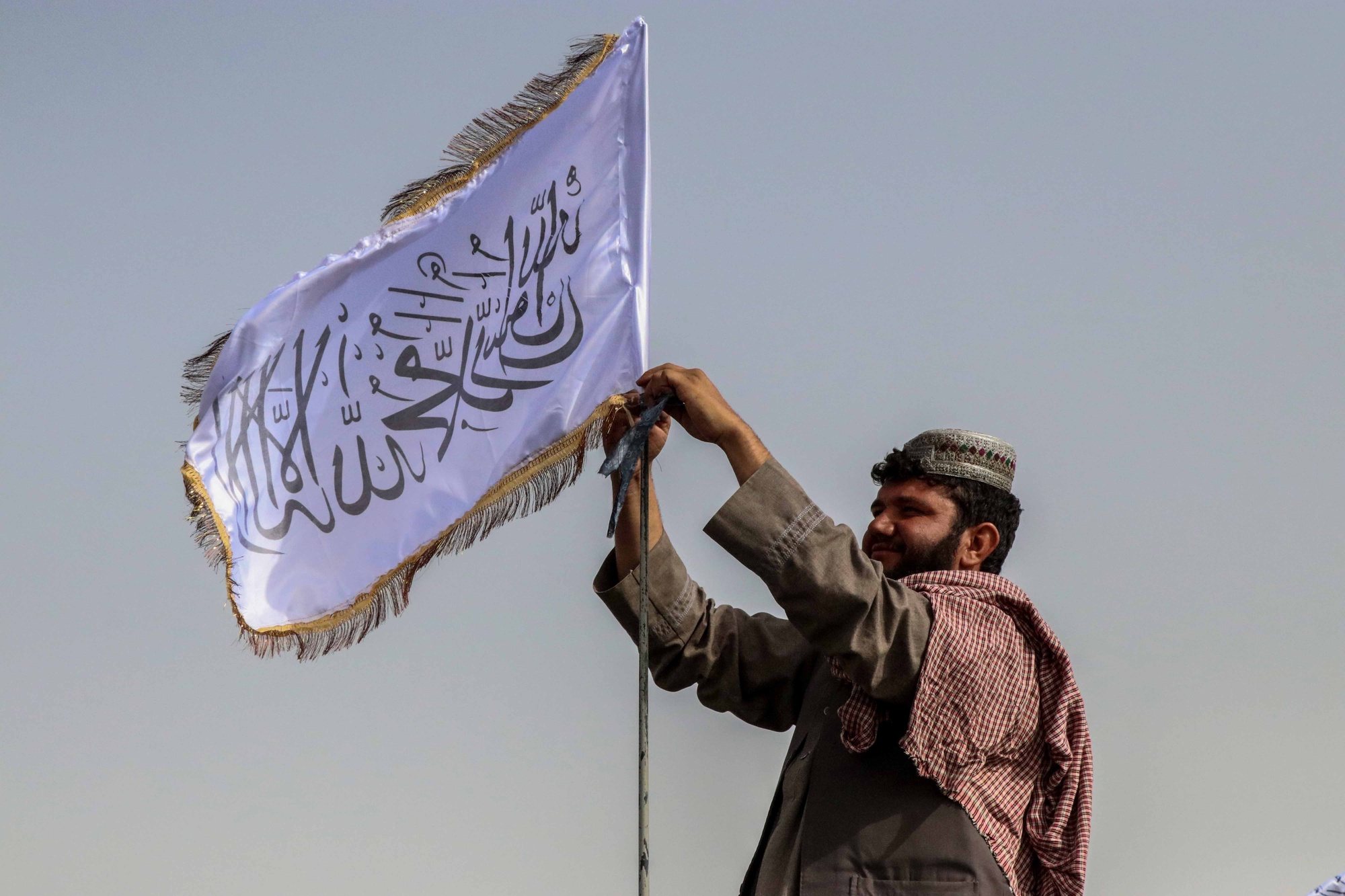 epaselect epa09417739 A Taliban fighter raises their flag on a vehicle as they patrol in Kandahar, Afghanistan, 17 August 2021. Taliban co-founder Abdul Ghani Baradar, on 16 August, declared victory and an end to the decades-long war in Afghanistan, a day after the insurgents entered Kabul to take control of the country. Baradar, who heads the Taliban political office in Qatar, released a short video message after President Ashraf Ghani fled and conceded that the insurgents had won the 20-year war.  EPA/STRINGER