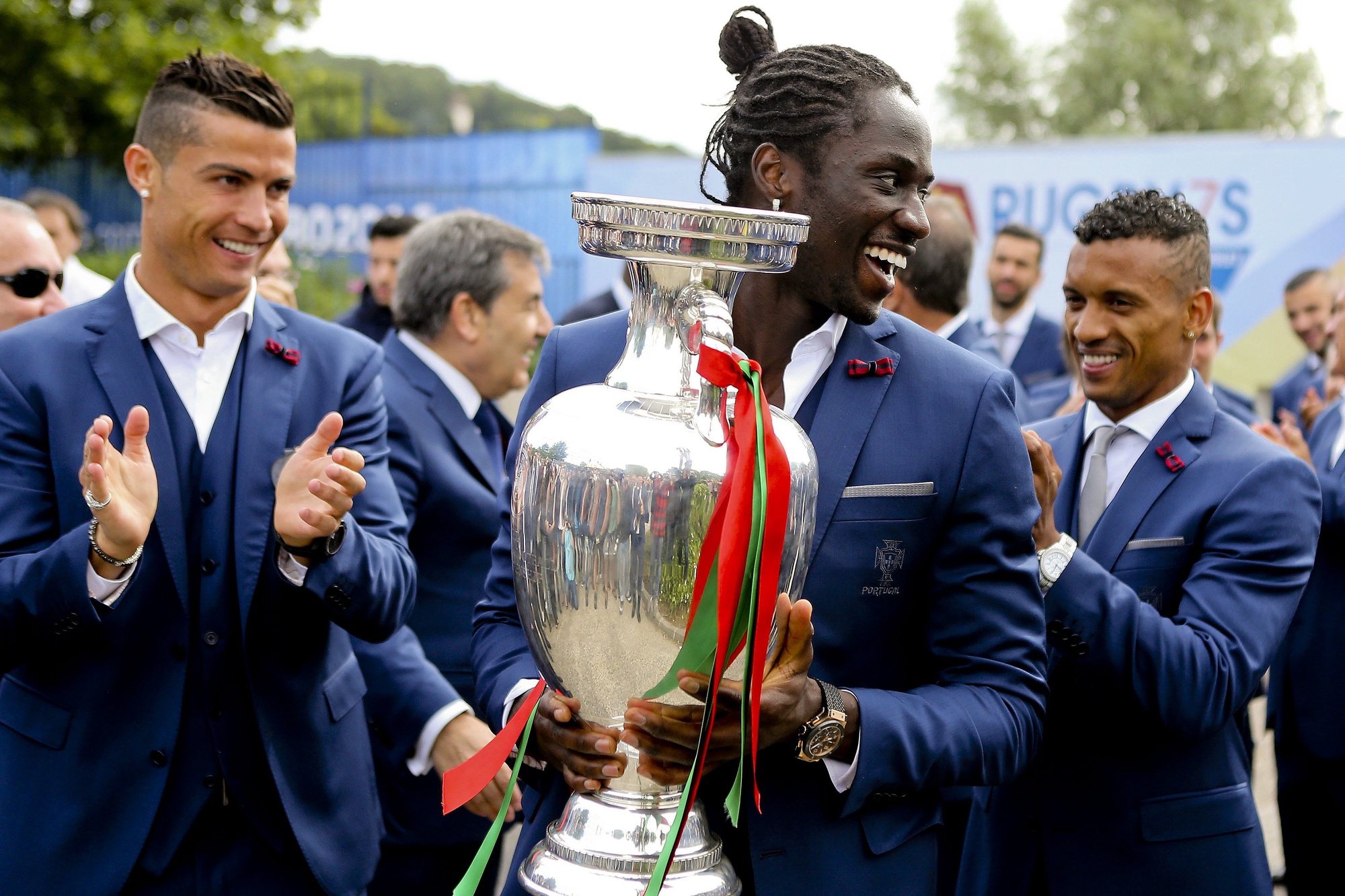 epaselect epa05420242 Portugal player Eder (C) holds the UEFA Euro 2016 trophy accompanied by Cristiano Ronaldo (L), and Nani (R) display the winners trophy to supporters before leaving Marcoussis near Paris, France 11 July 2016. Portugal beat France by 1-0 in the Euro 2016 final.  EPA/MIGUEL A. LOPES