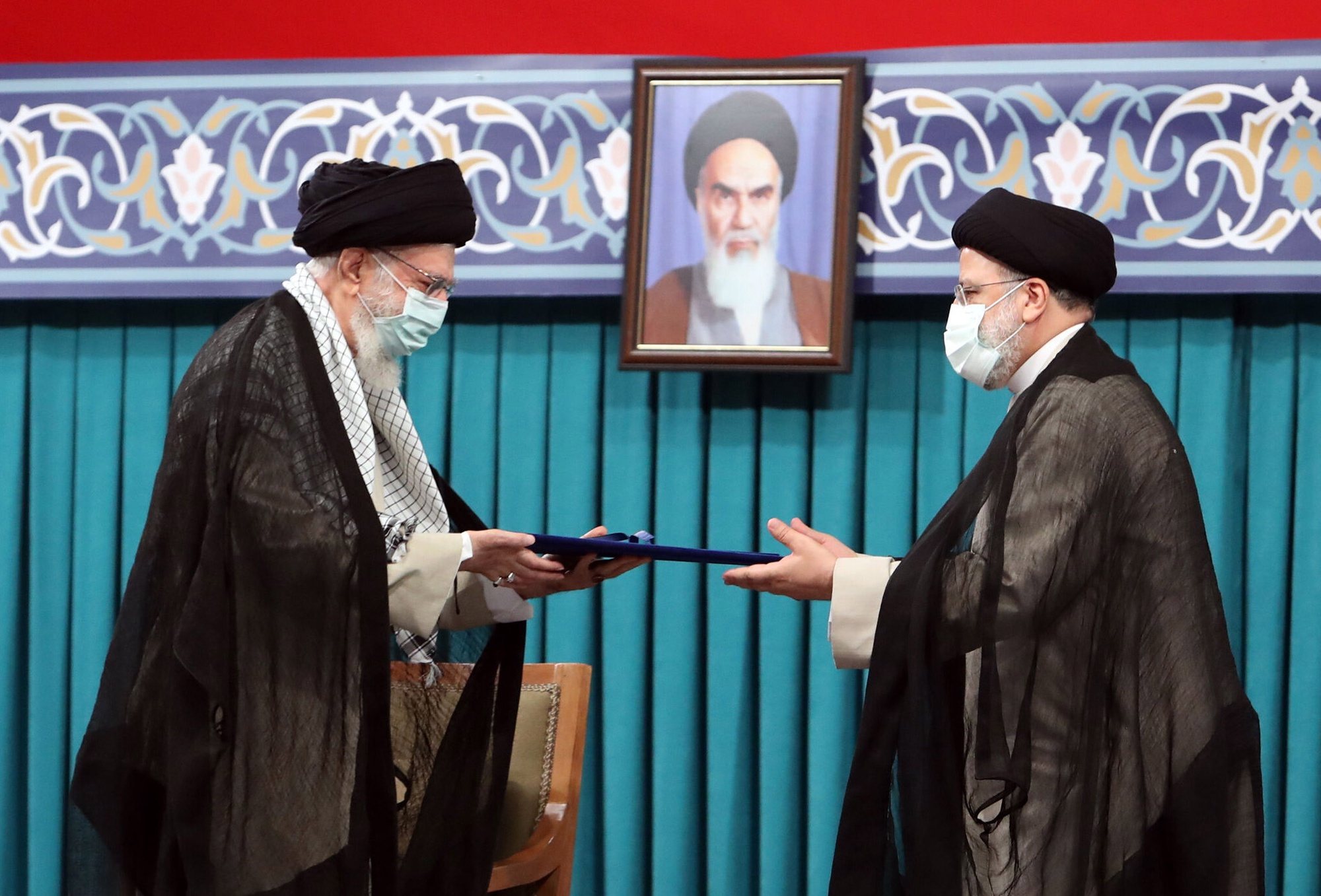 epa09389894 A handout picture made available by Iran&#039;s Supreme Leader Office shows Iranian supreme leader Ayatollah Ali khamenei (L) handing over the presidential precept to new Iranian president Ebrahim Raisi (R), in Tehran, Iran, 03 August 2021. Iranian presidents are first approved by the supreme leader, who according to constitution is the actual head of state, and then take the oath before parliament. Ebrahim Raisi has been inaugurated as the new president of the Islamic Republic of Iran on 03 August 2021, as the country is facing an economic crisis along with the coronavirus disease (COVID-19) pandemic.  EPA/IRAN&#039;S SUPREME LEADER OFFICE HANDOUT  HANDOUT EDITORIAL USE ONLY/NO SALES