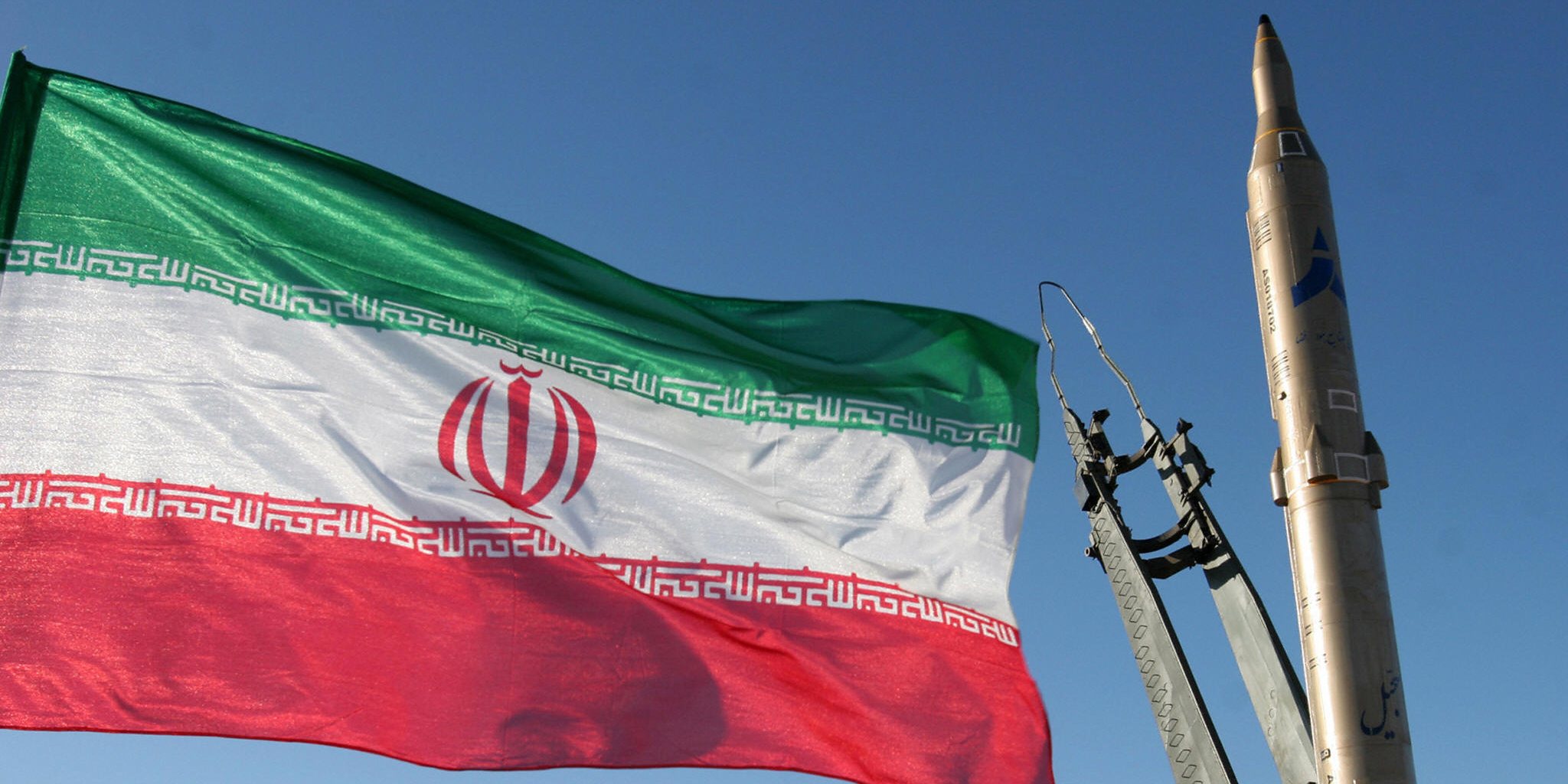 An Iranian flag flutters next to a groun