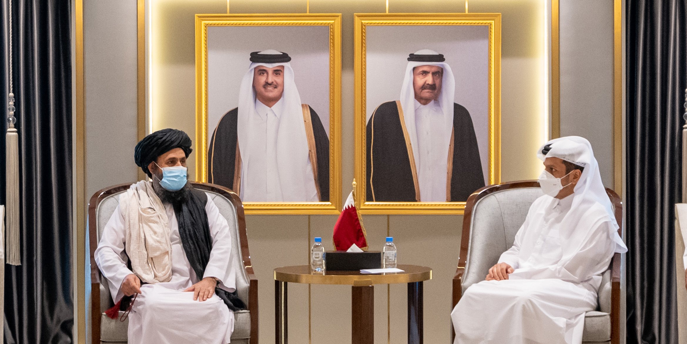 Ministro dos Negócios Estrangeiros do Qatar, Mohammed bin Abdulrahman Al Thani (dta.), ao lado de Abdul Ghani Baradar, um dos líderes dos talibãs, em Doha, dois dias depois de os talibã terem tomado o poder no Afeganistão