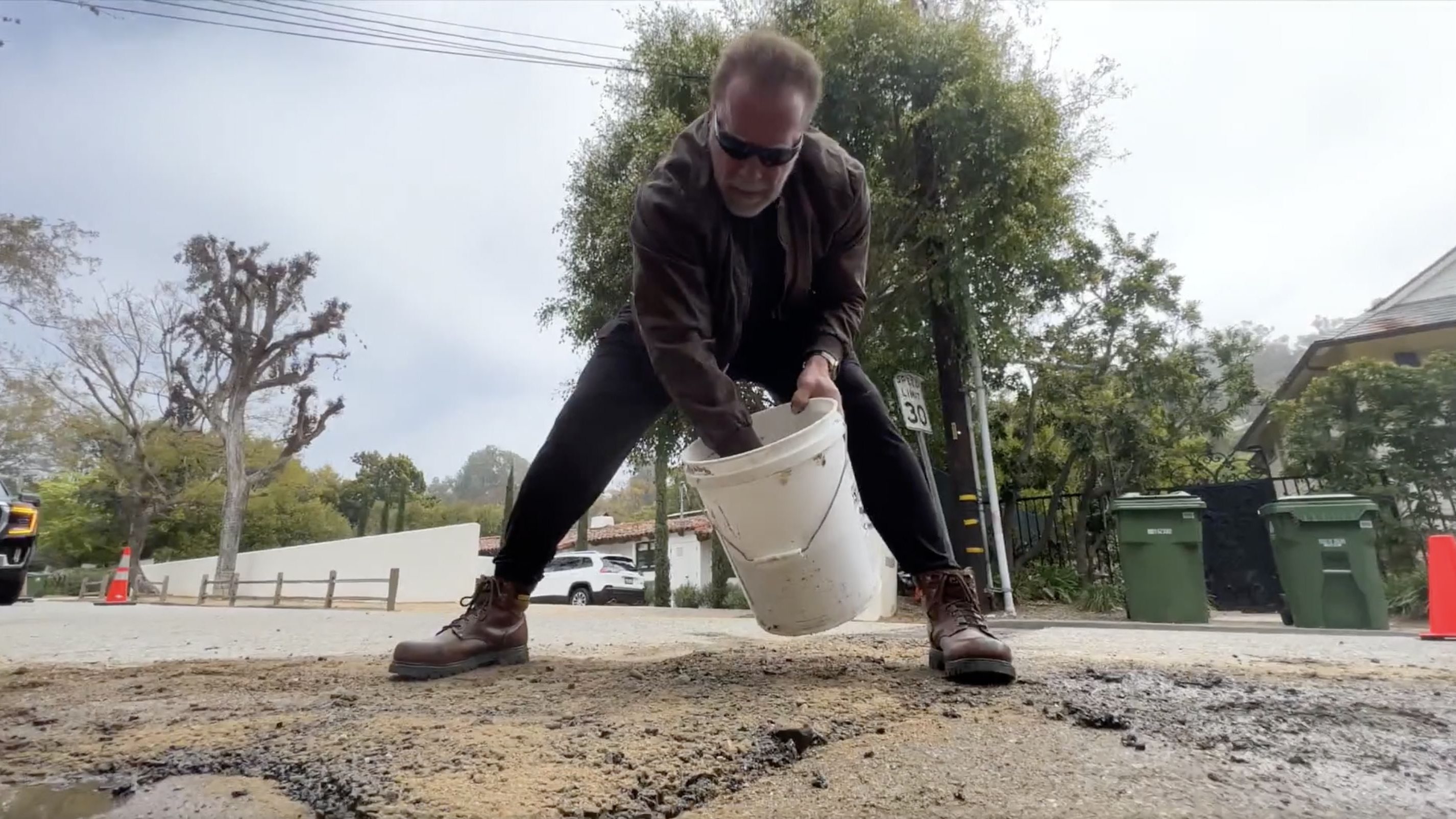 No vídeo, vê-se Schwarzenegger a derramar sacos de asfalto no buraco