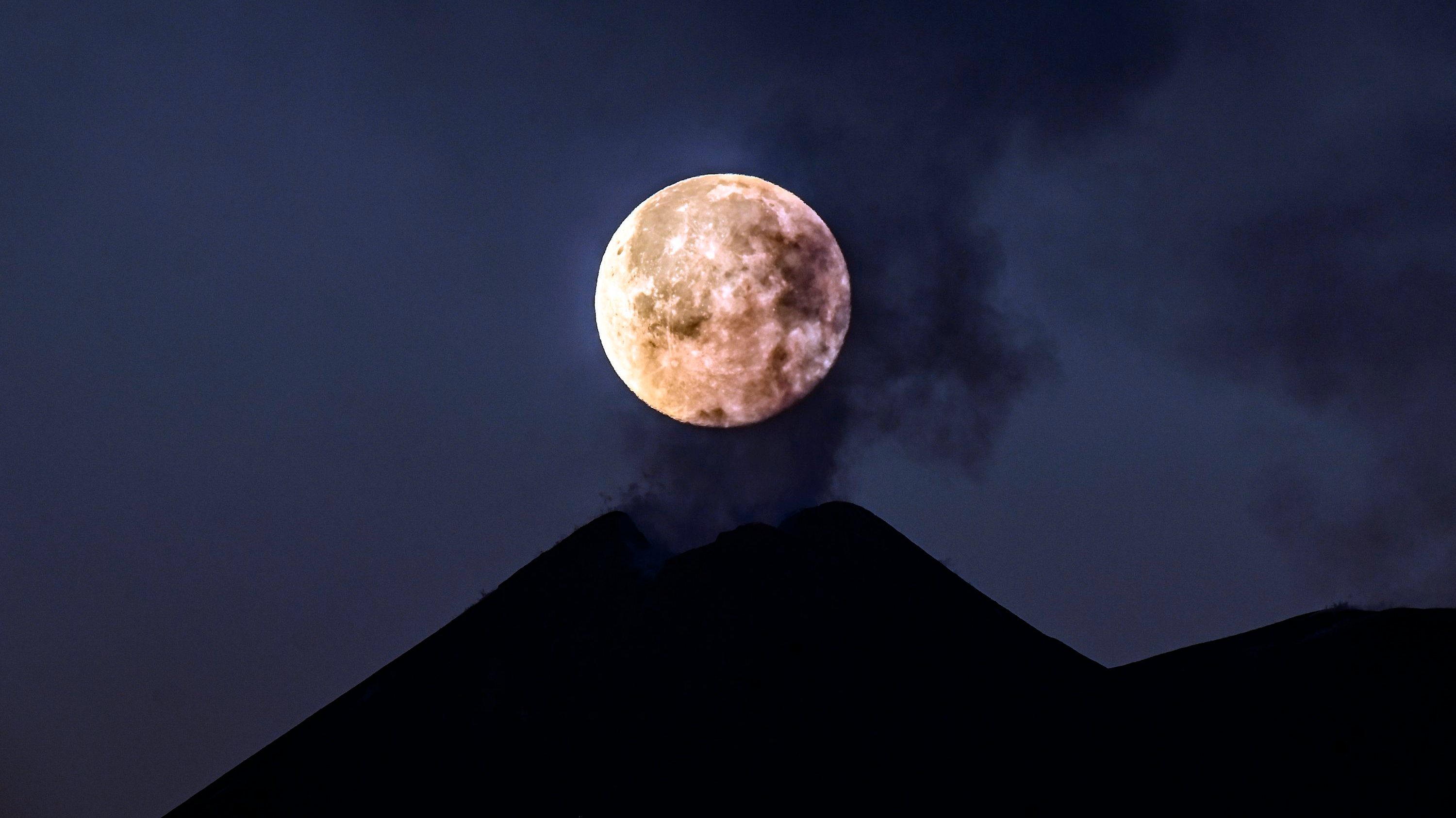 A Lua Cheia junto a uma das crateras do vulcão Etna em fevereiro de 2021