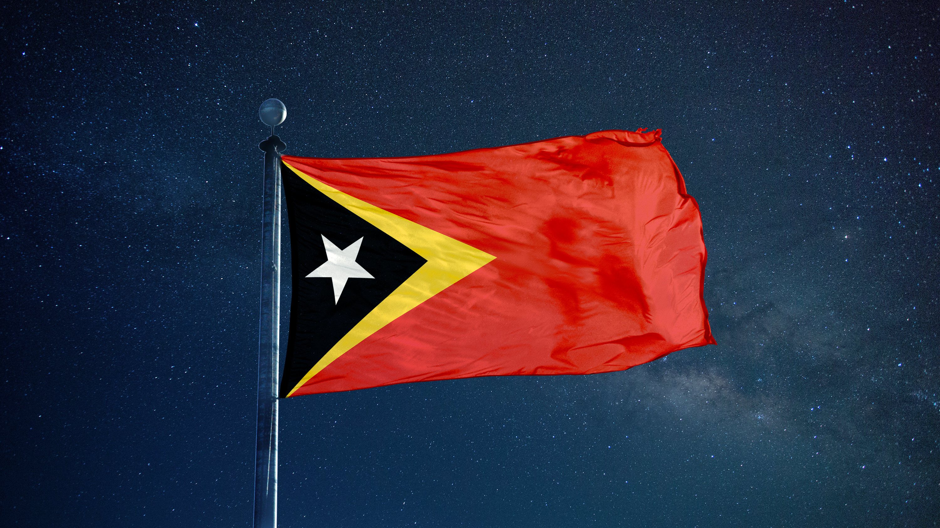 Low Angle View Of East Timor Flag Against Star Field Sky