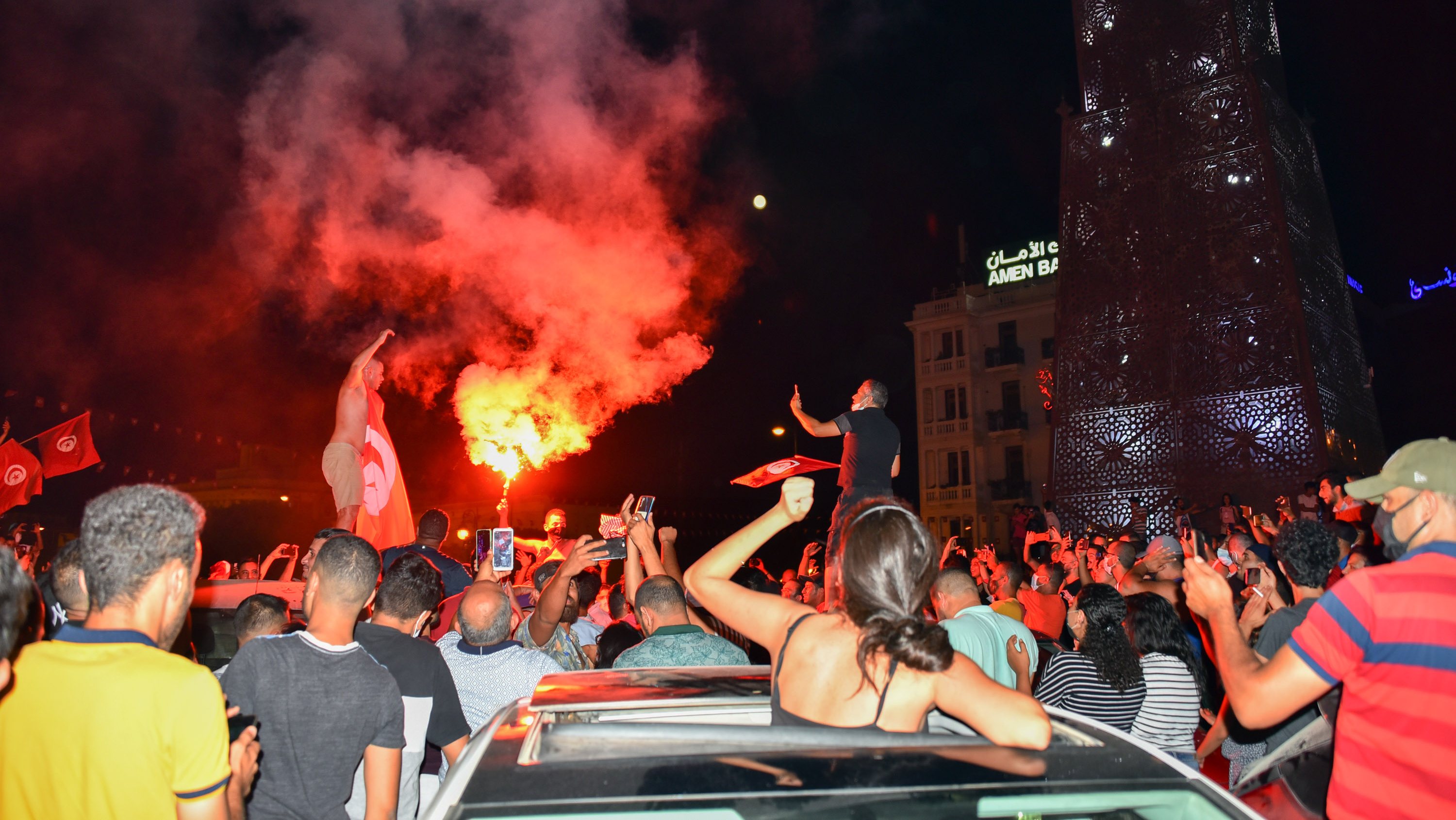 People celebrate on the street after the Tunisian President