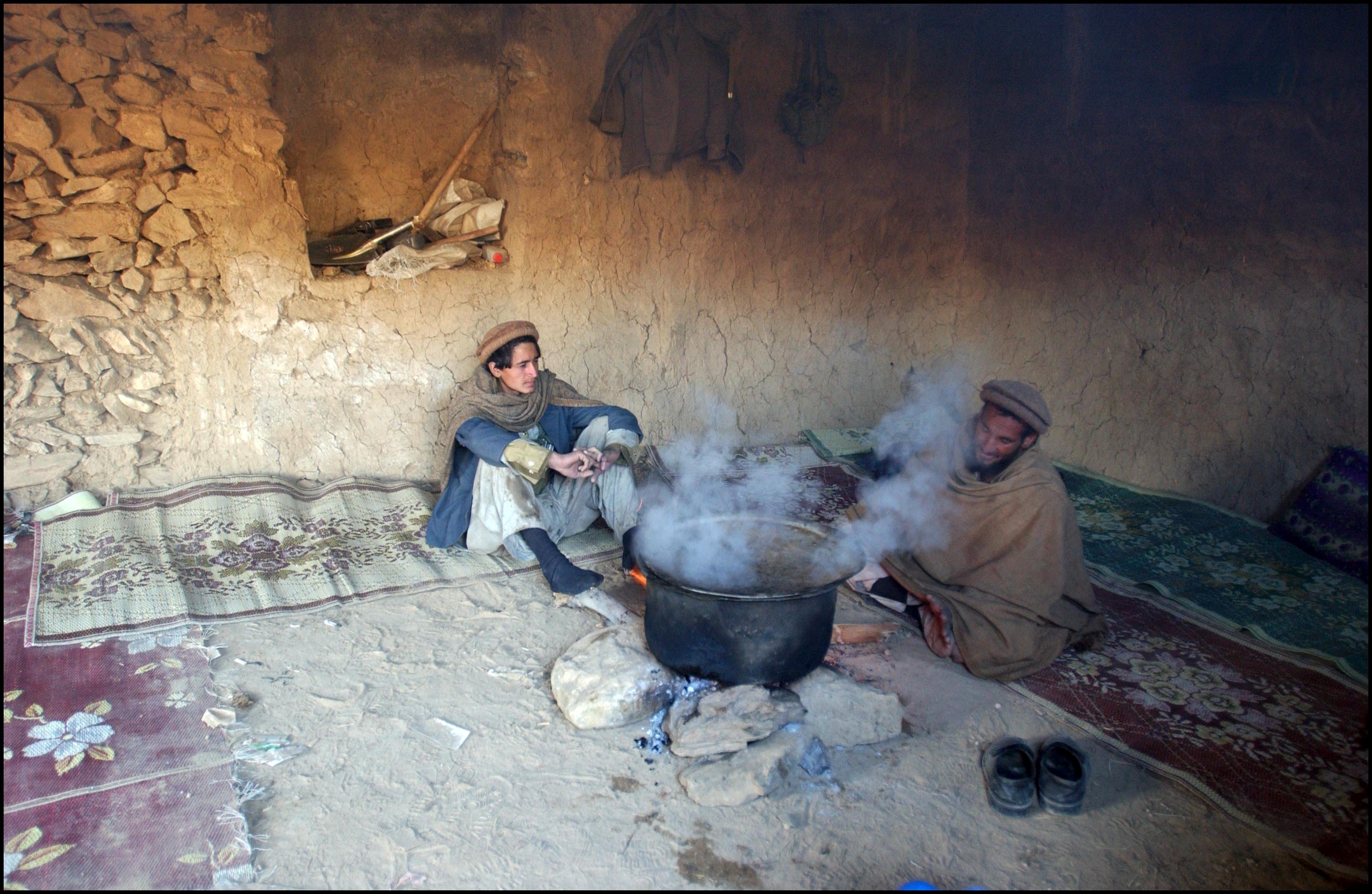Eastern Alliance Moudjahidin Fighters Prepare A Meal Inside A Captured Cave, Which Supposedly Belonged To Al Qaeda Leader Osama Bin Laden, In The Mountains Of Tora Bora In Eastern Afghanistan On December 13Th, 2001 In Tora Bora, Afghanistan.