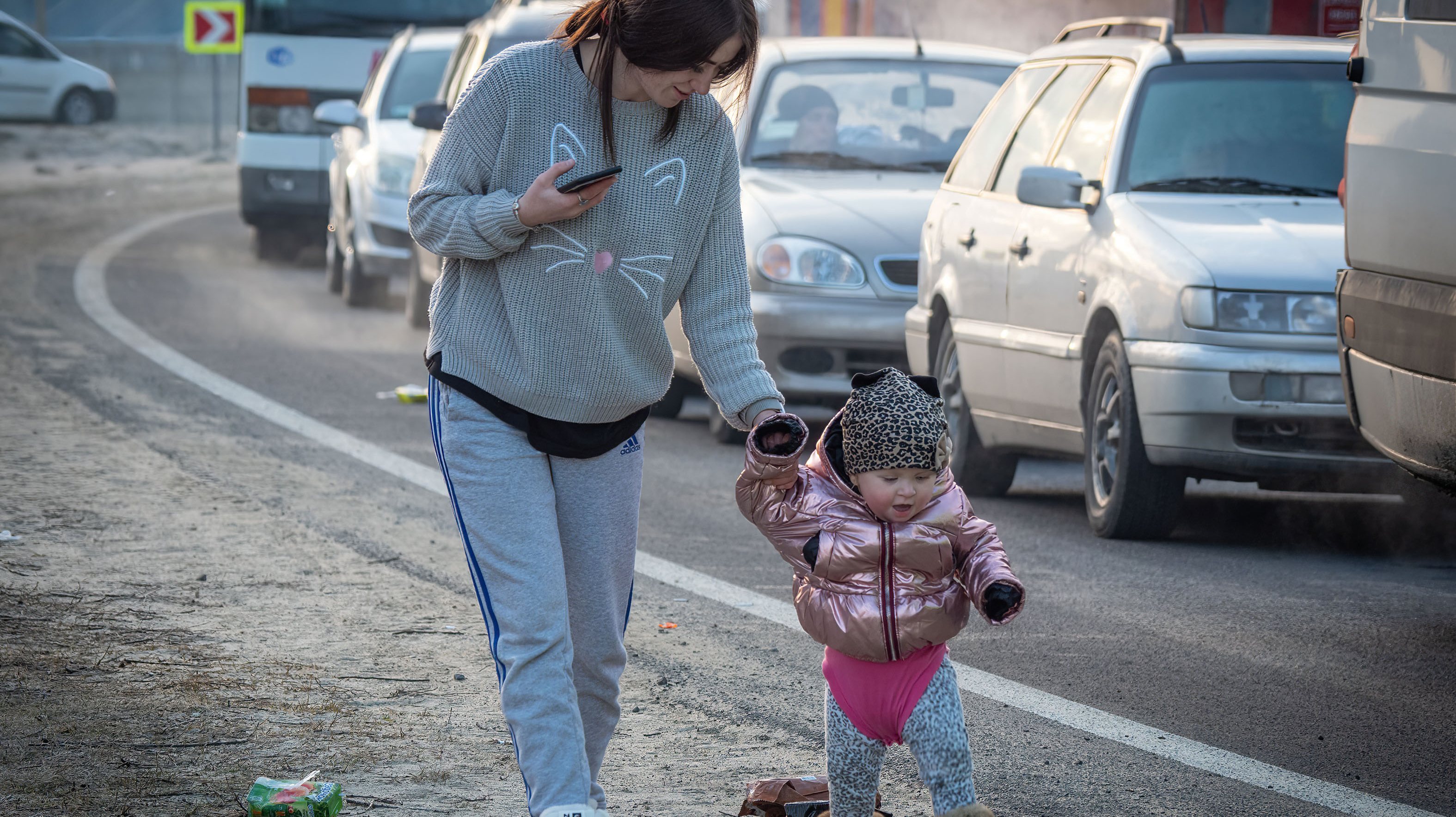 Uma mulher e a filha a caminhar em direção à fronteira polaca