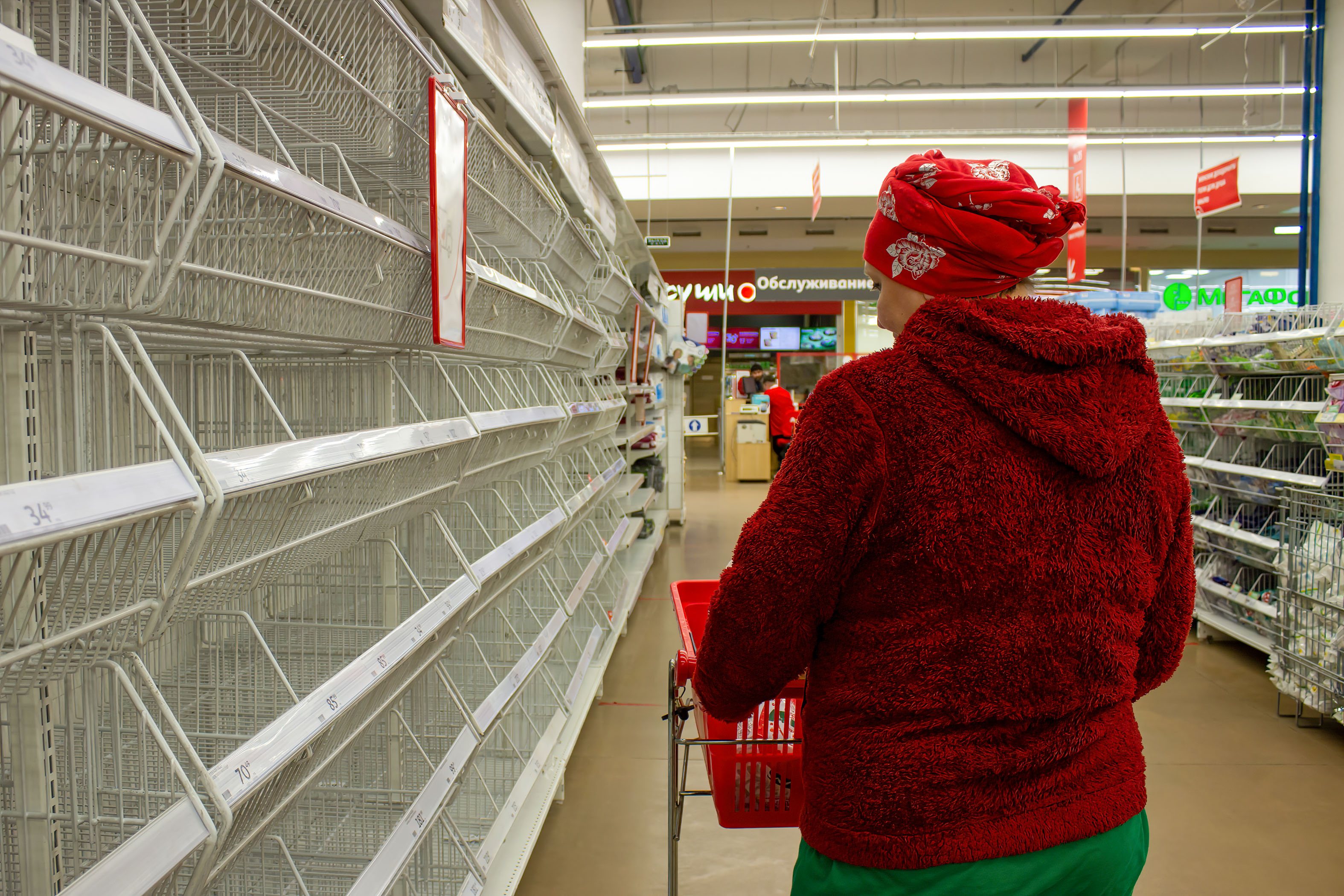 A woman looks at empty shelves in a supermarket in Moscow.