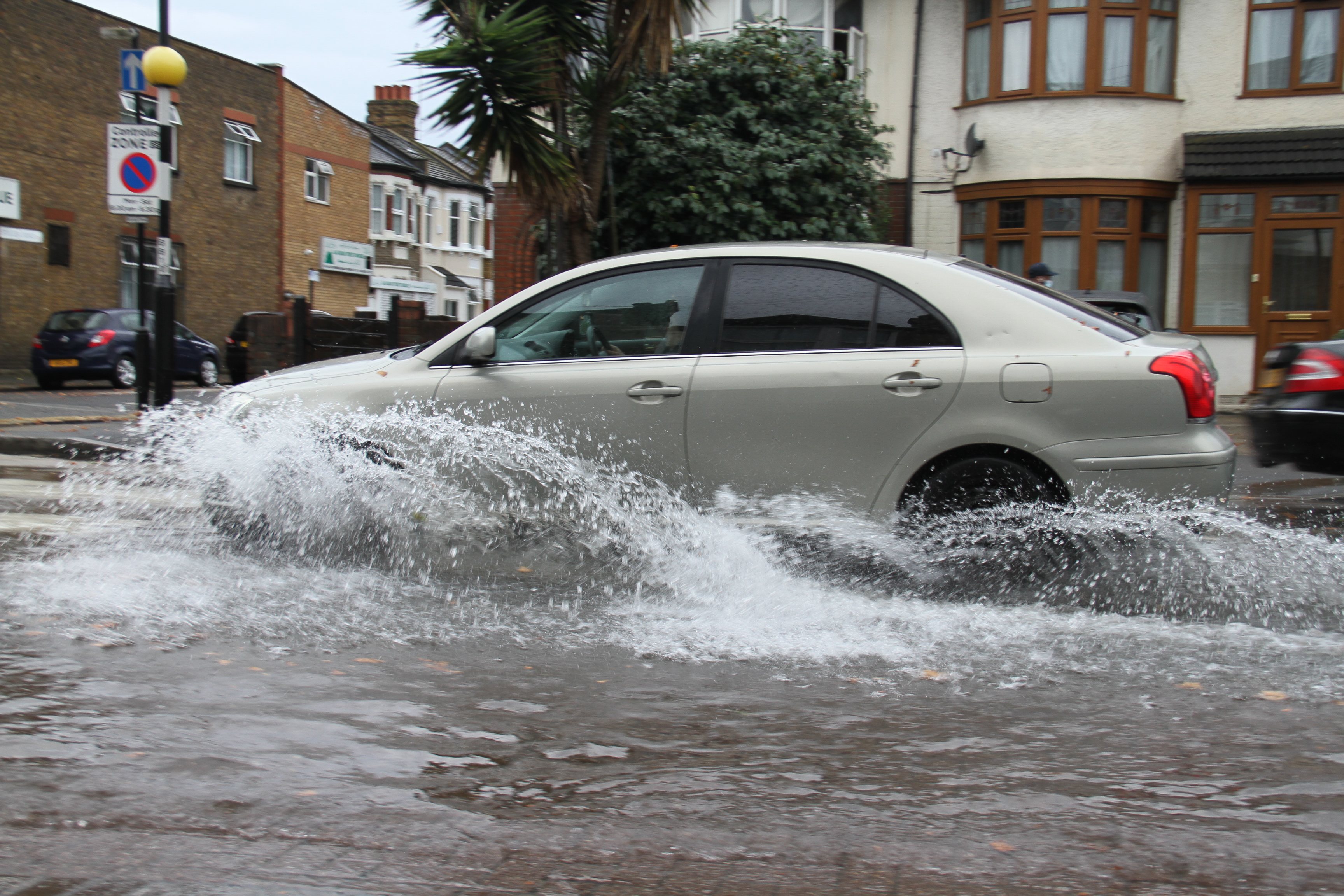 A car drives through flooding on a road in East London