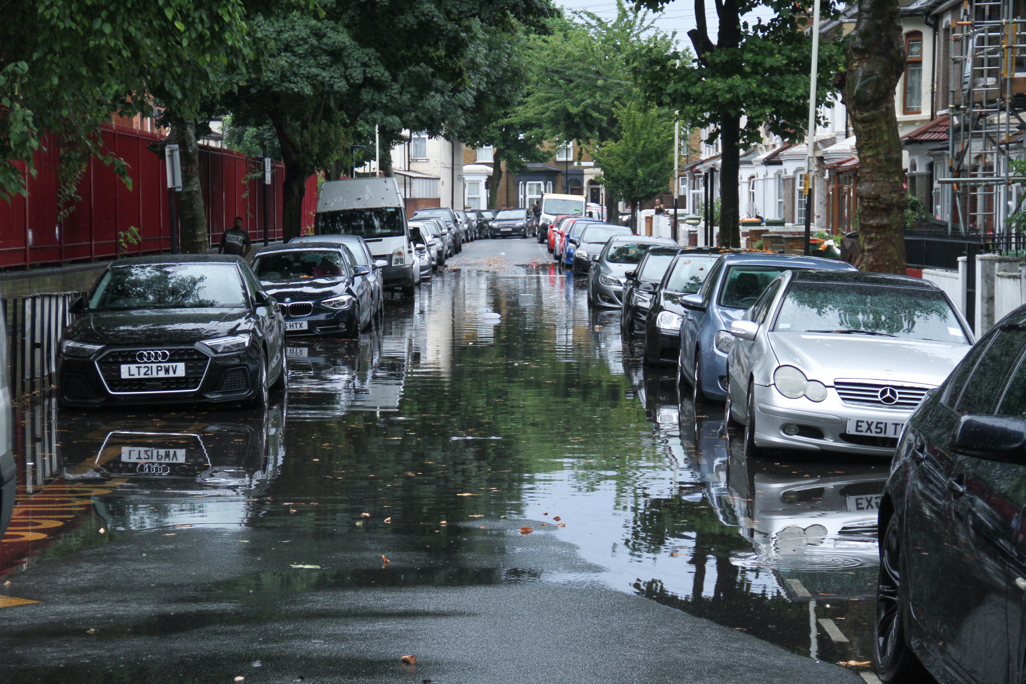 Vehicles seen parked on a flooded street in a suburb in East