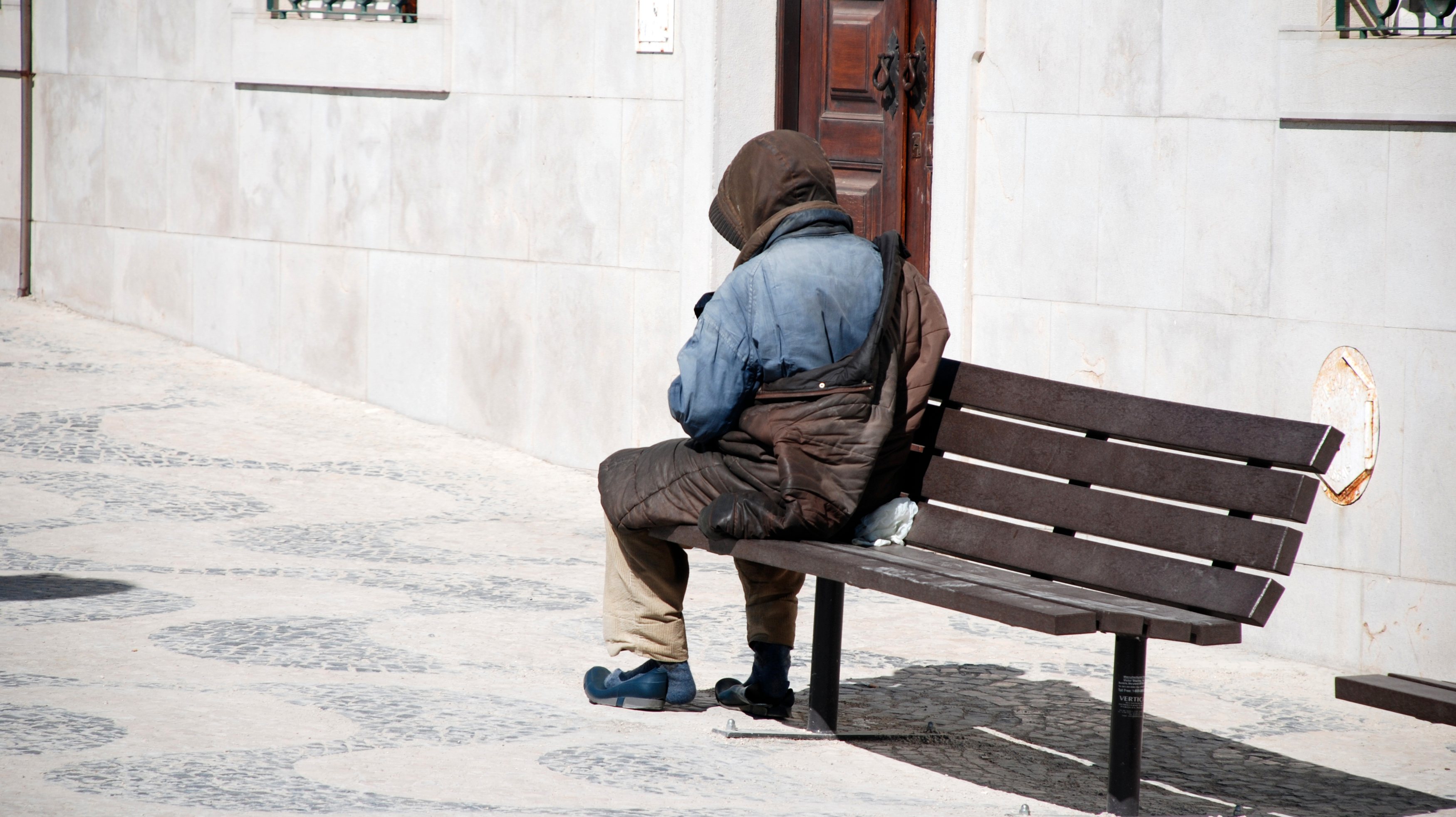 Homeless man on bench in Lisbon, Portugal.