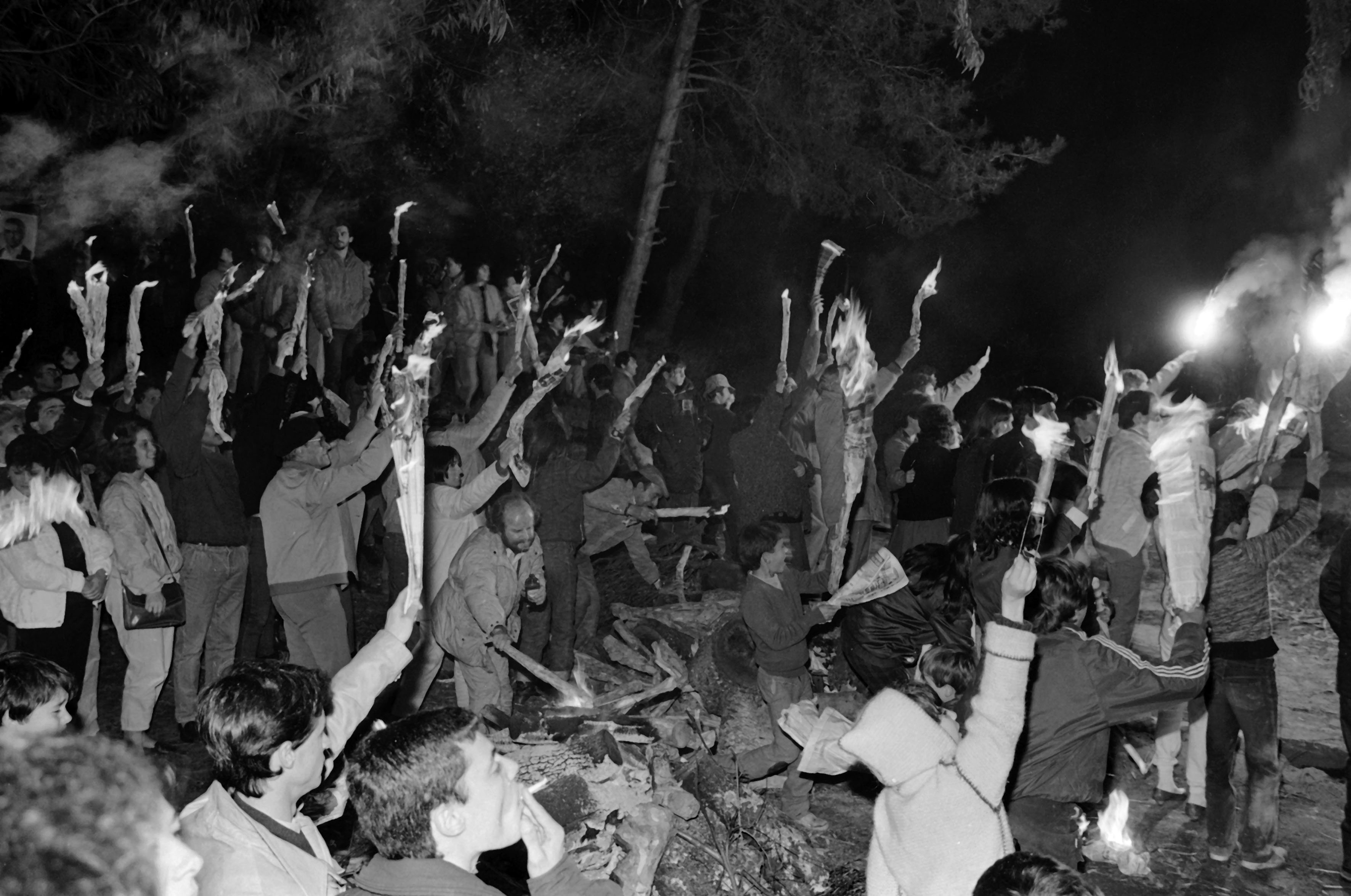 Populares com tochas durante a vigília de solidariedade para com Otelo, detido no Forte da Caxias, na madrugada de 24 de abril de 1986. António Cotrim / Lusa