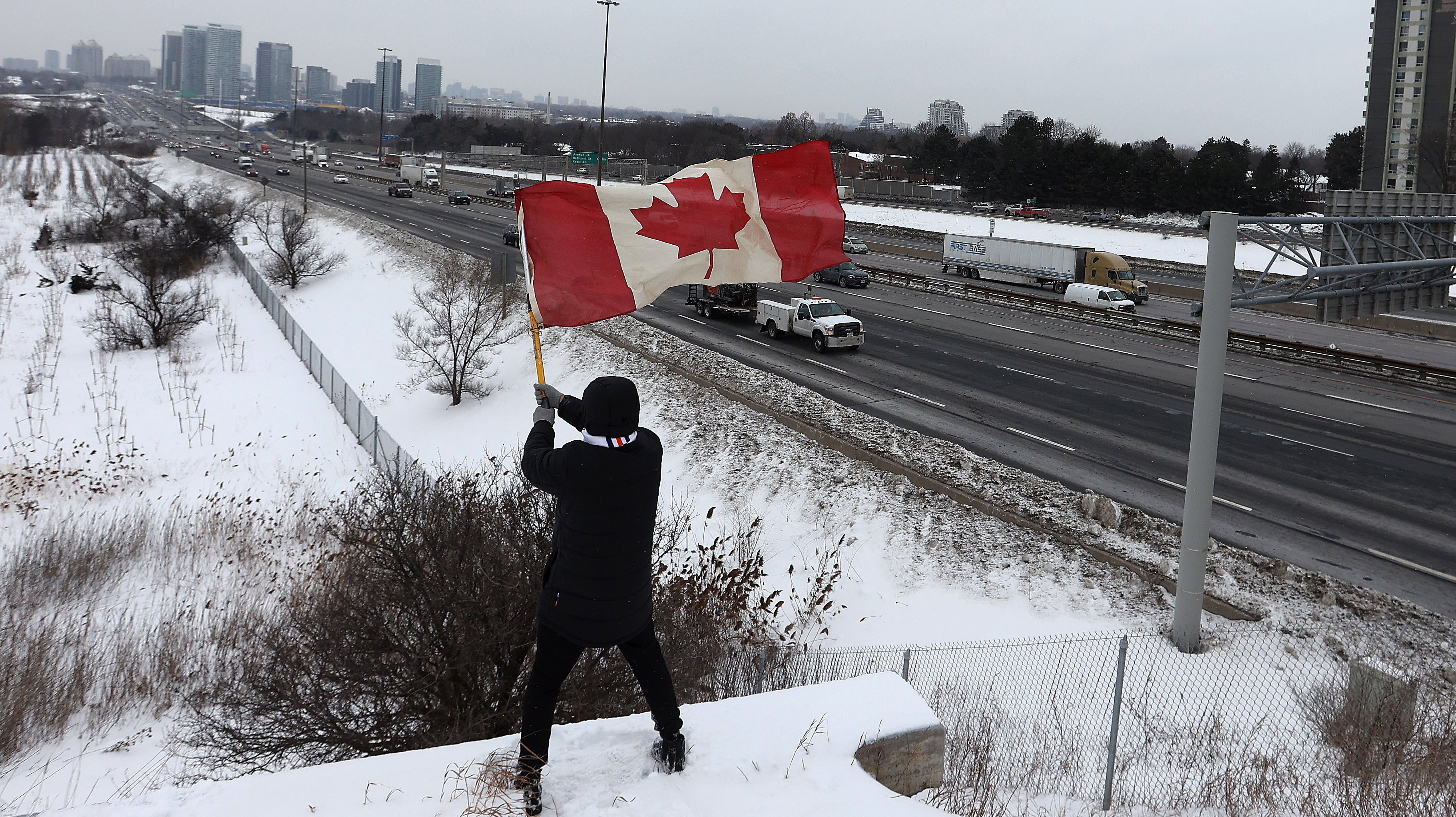 Protesters gather onto the Don Mills bridge over Highway 401 in a show of support for the Freedom Convoy of truckers on their way to Ottawa to protest vaccine mandates at the border