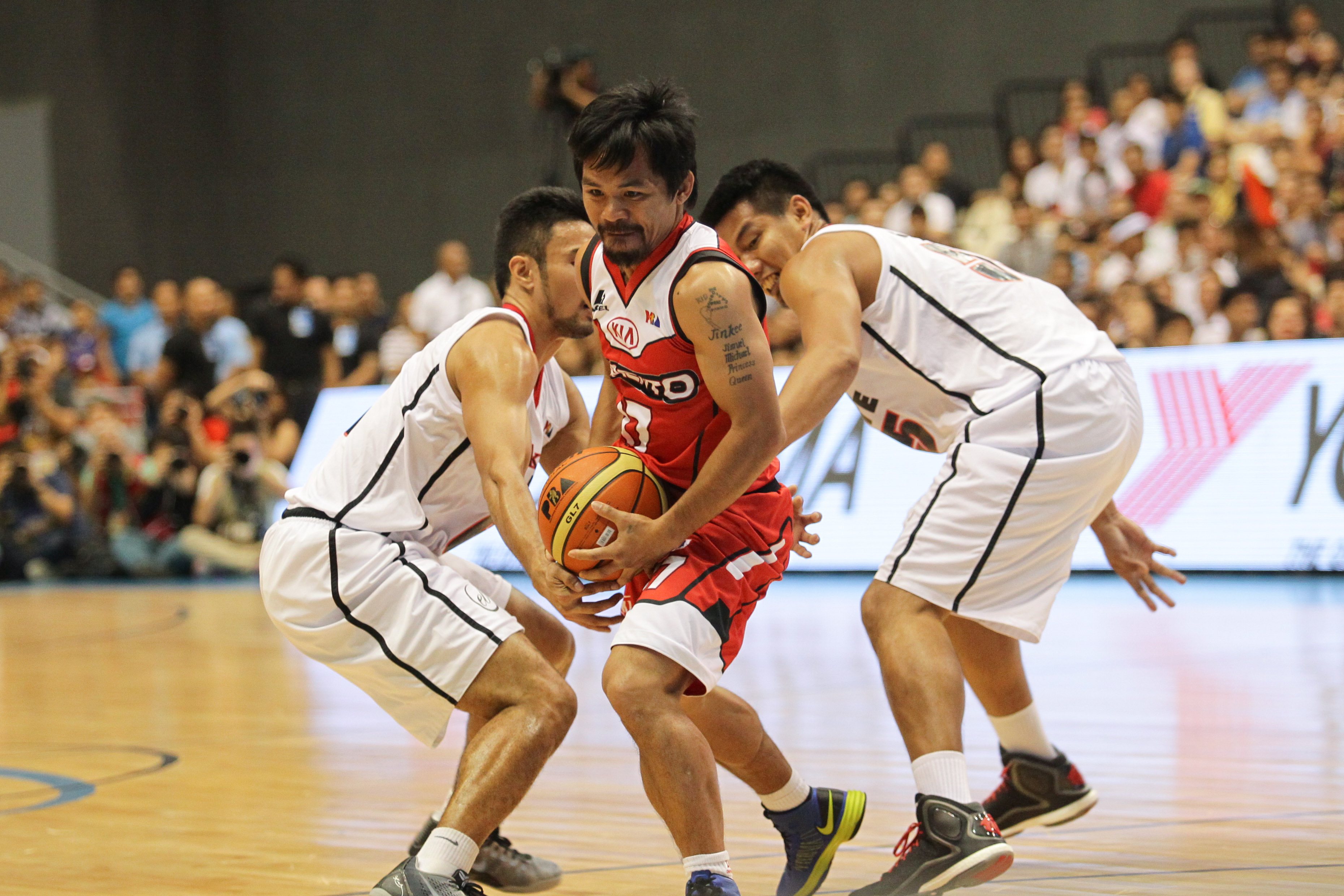 Manny Pacquiao of Kia (C) goes to the basket against