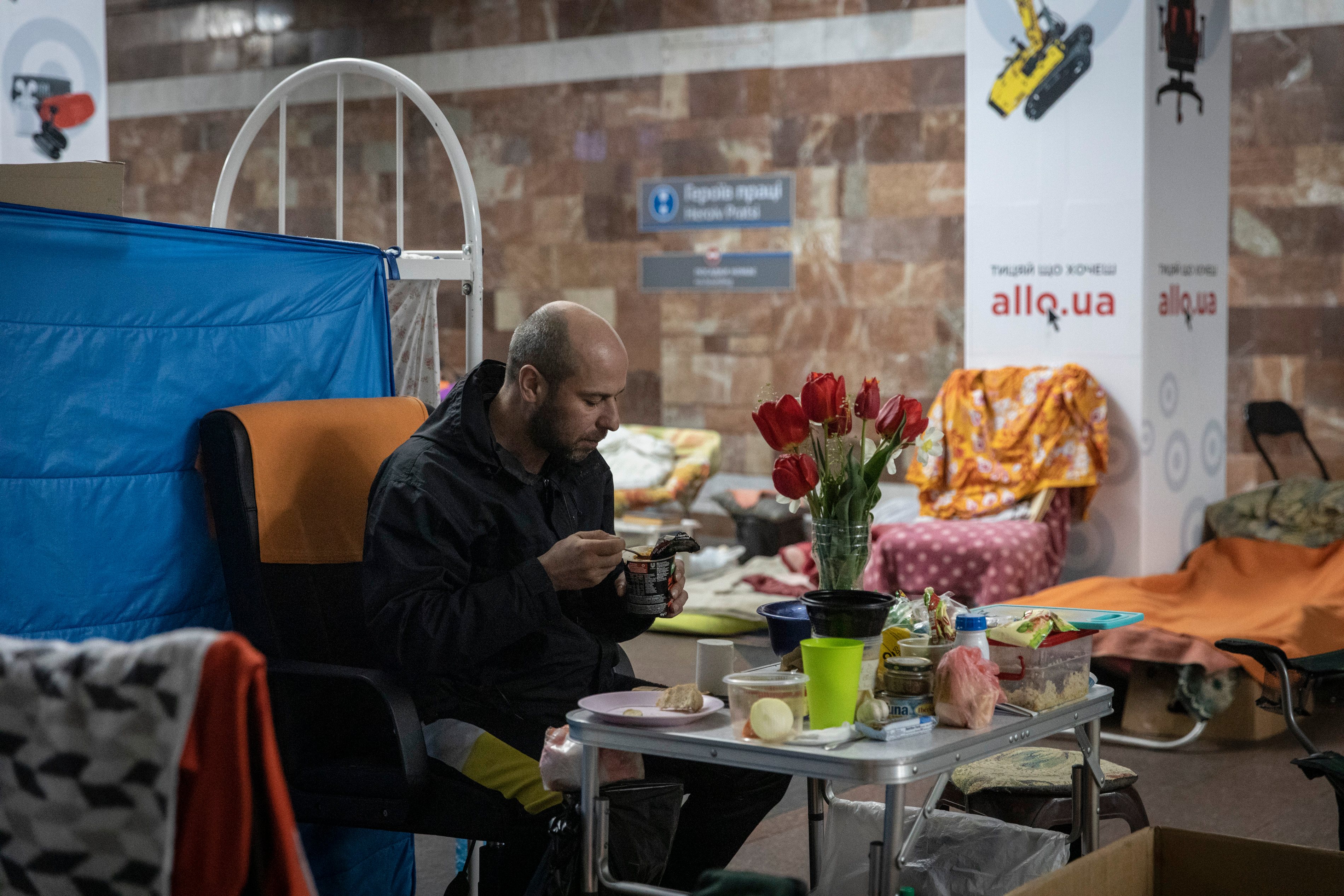 A man eats his meals in the metro station in Kharkiv