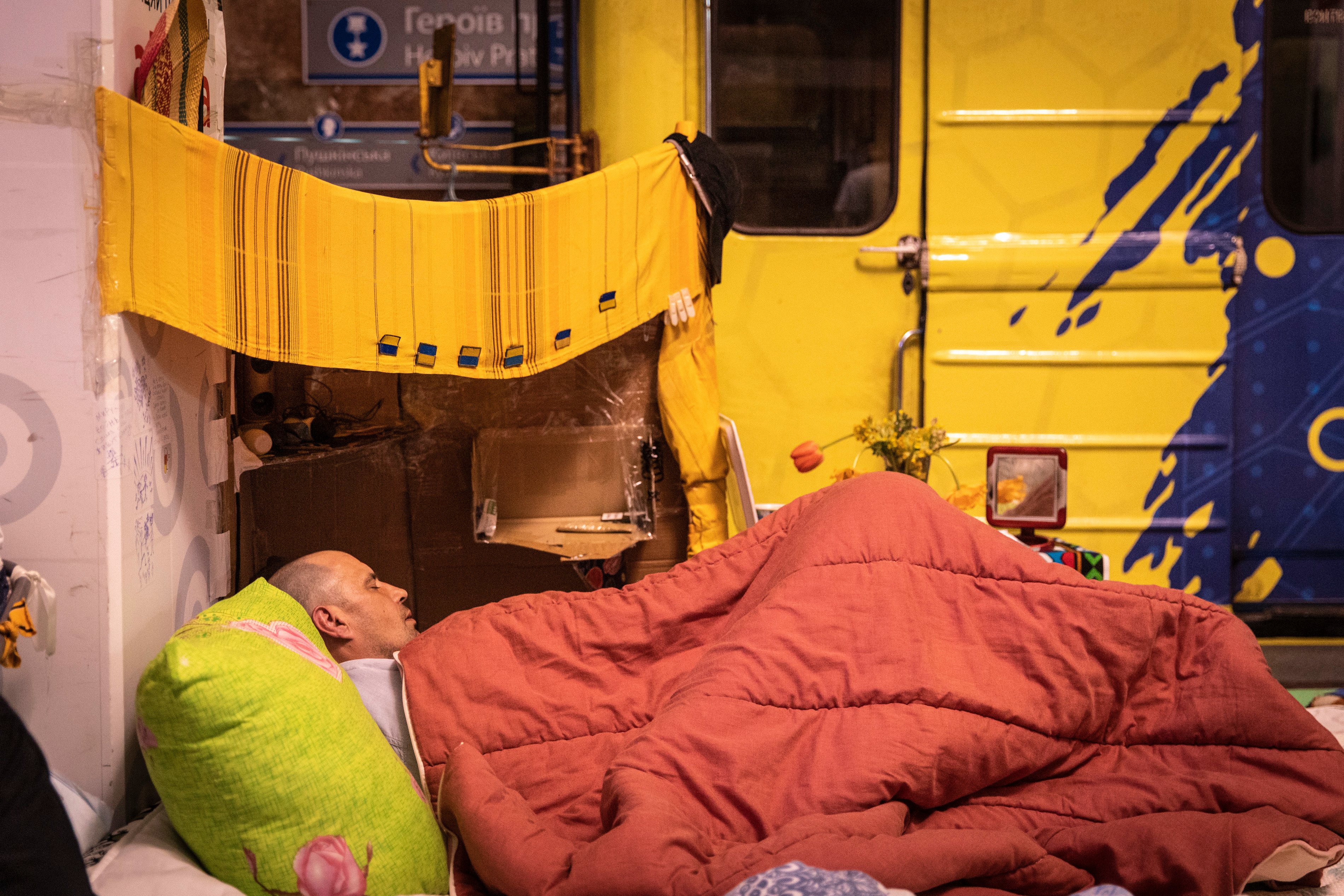 A man sleeps on his bed in the metro station in Kharkiv