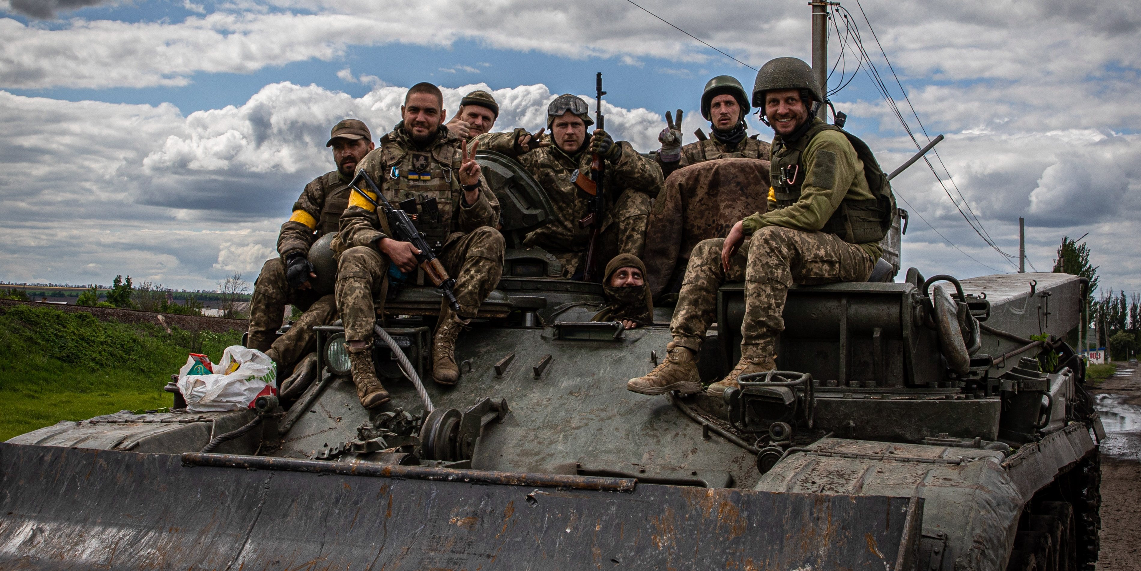 Ukrainian soldiers sitting on the armored vehicle depart for