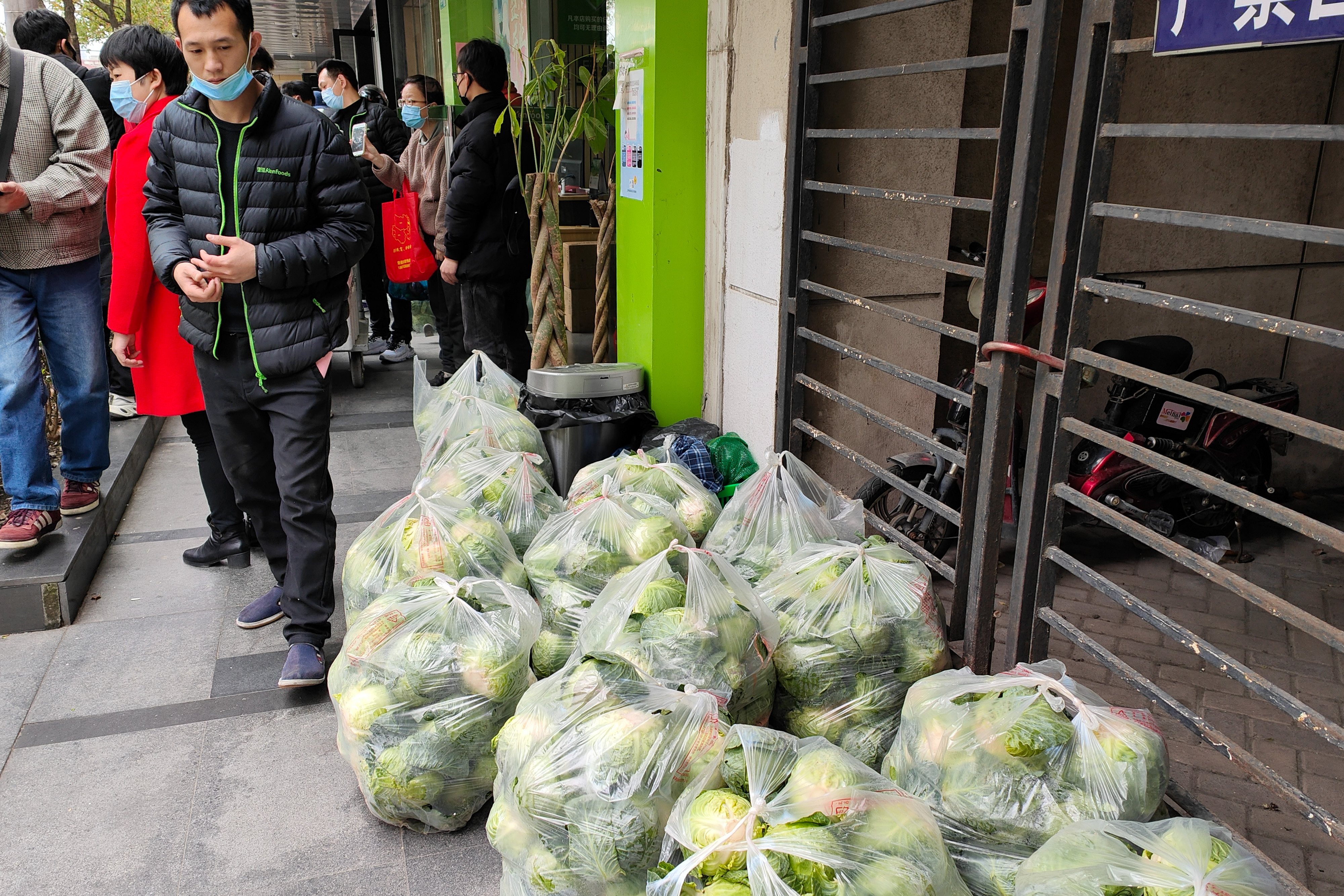 Habitantes no distrito de Yangpu, em Xangai, dirigem-se ao supermercados para comprar alimentos para os dias de confinamento