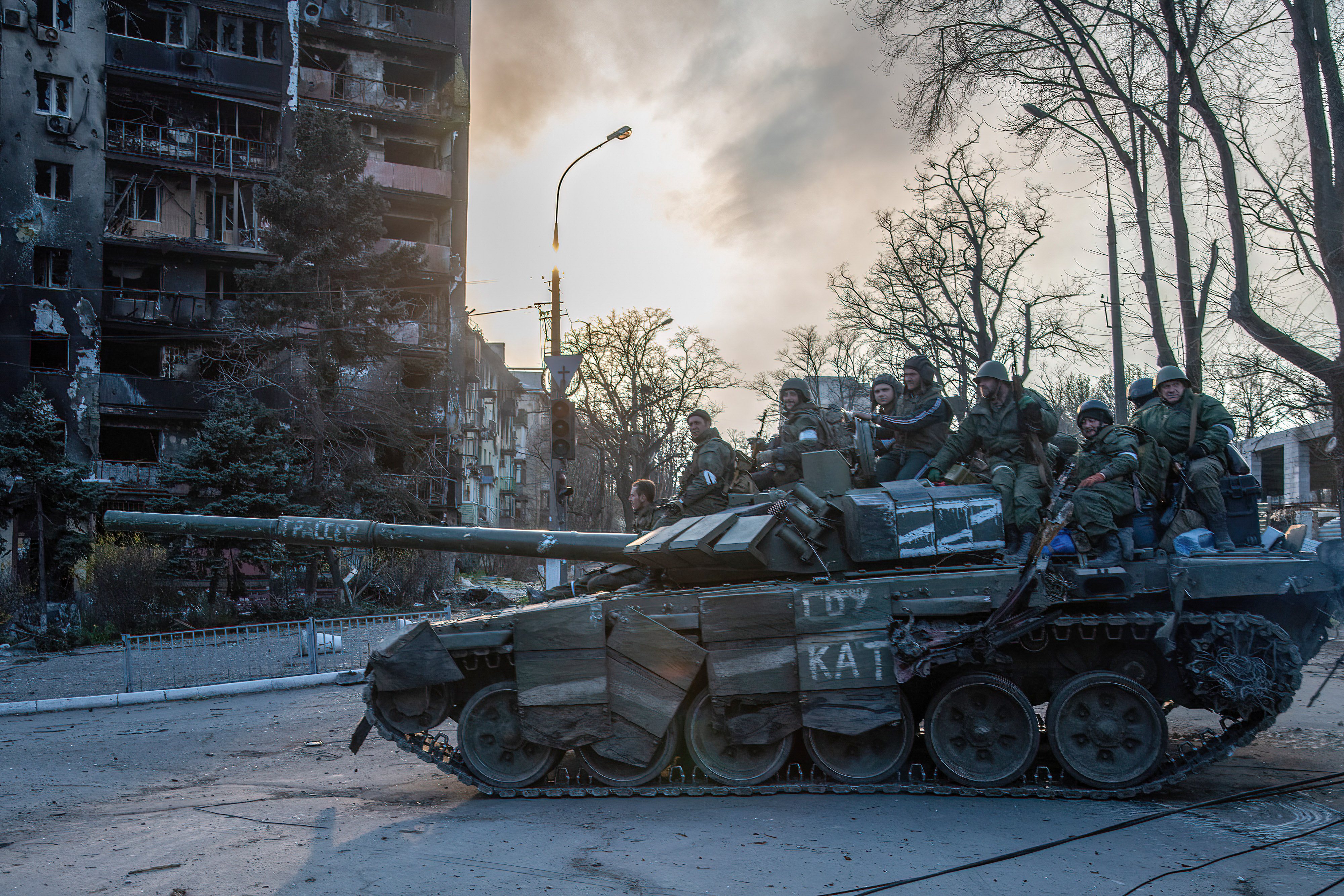 A DPR tank in a burning Mariupol neighborhood drives towards