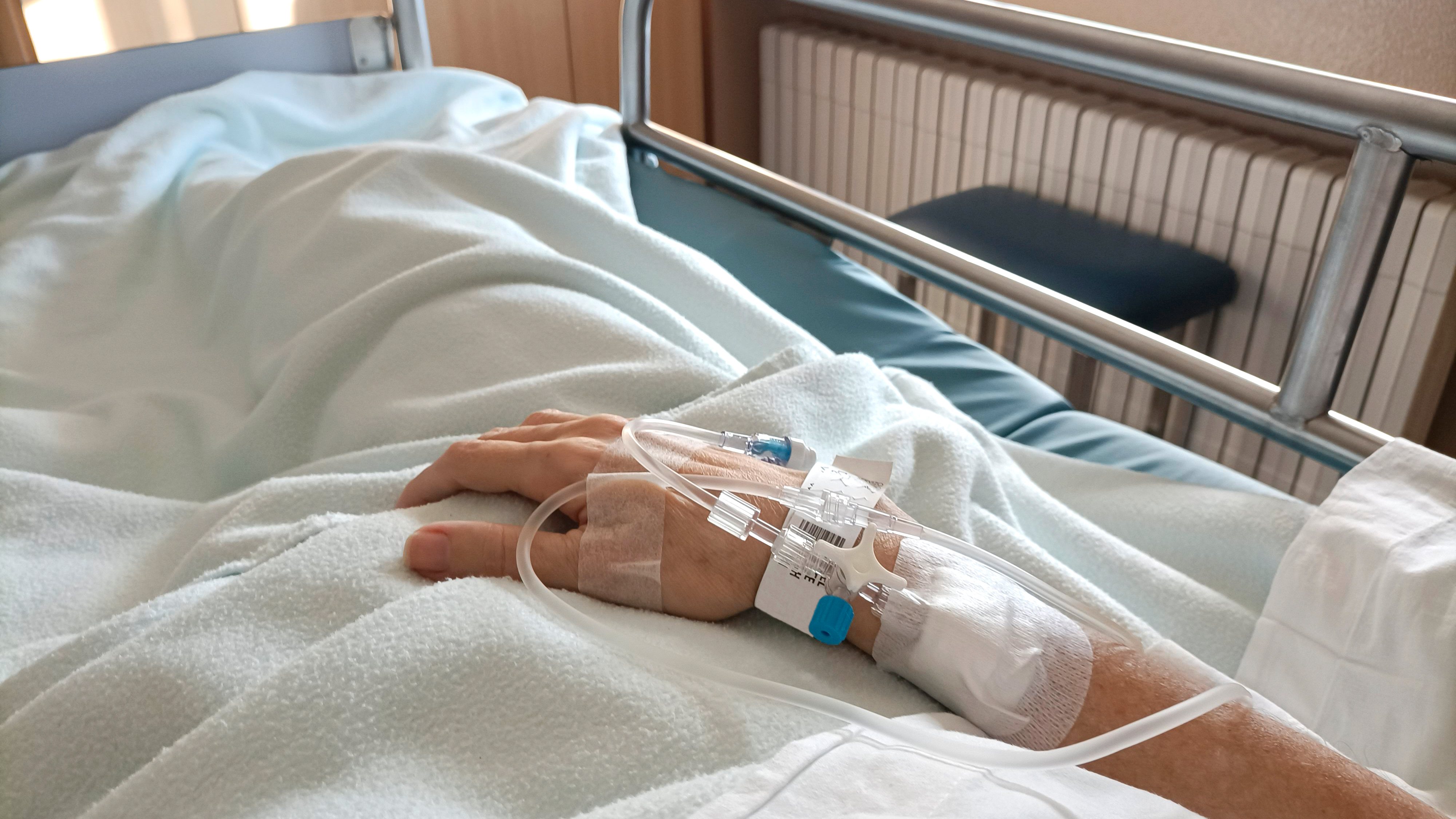 Midsection Of Patient With Iv Drip Relaxing On Hospital Bed