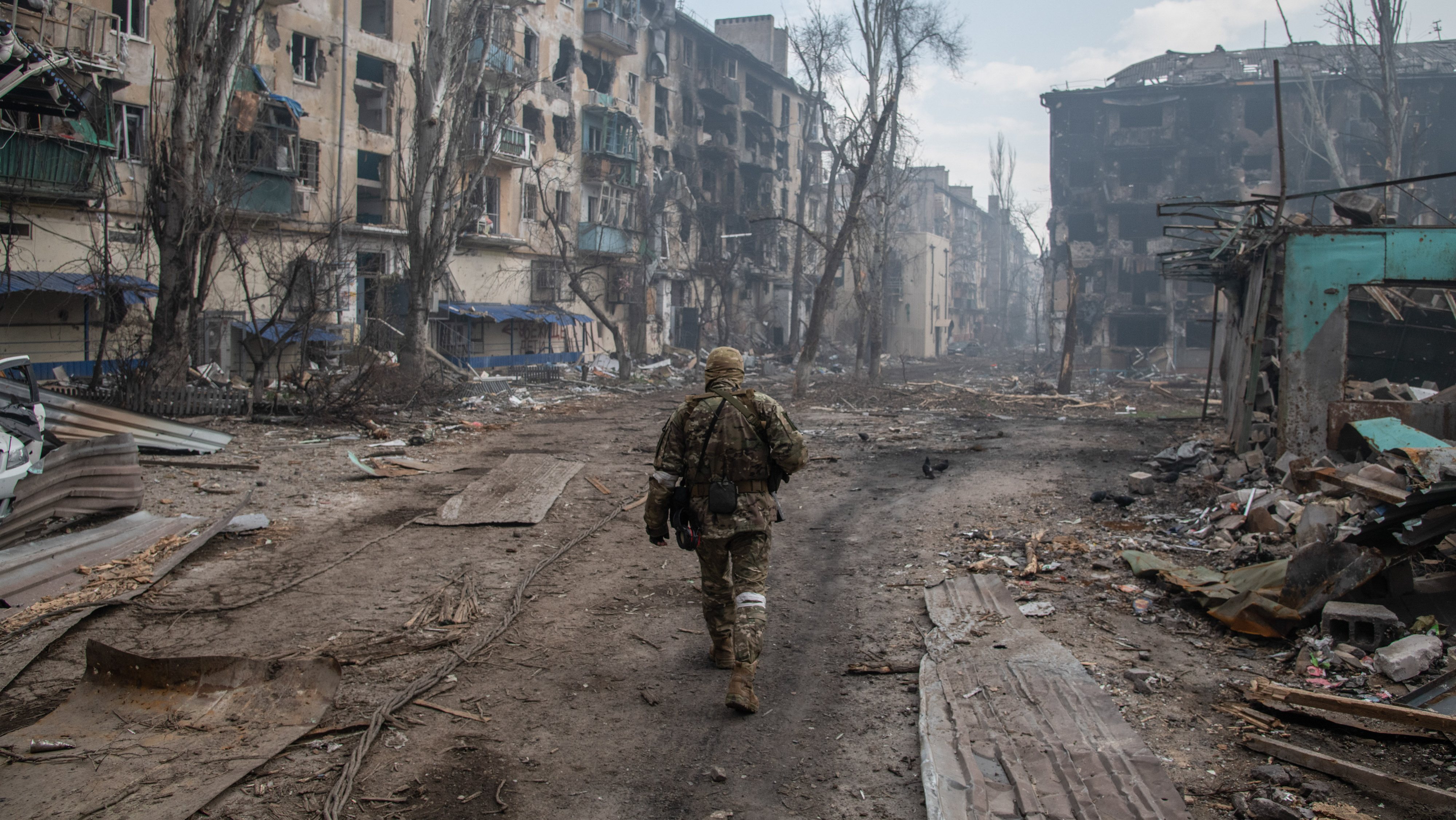 A Russian soldier walks amidst the rubble in Mariupol&#039;s