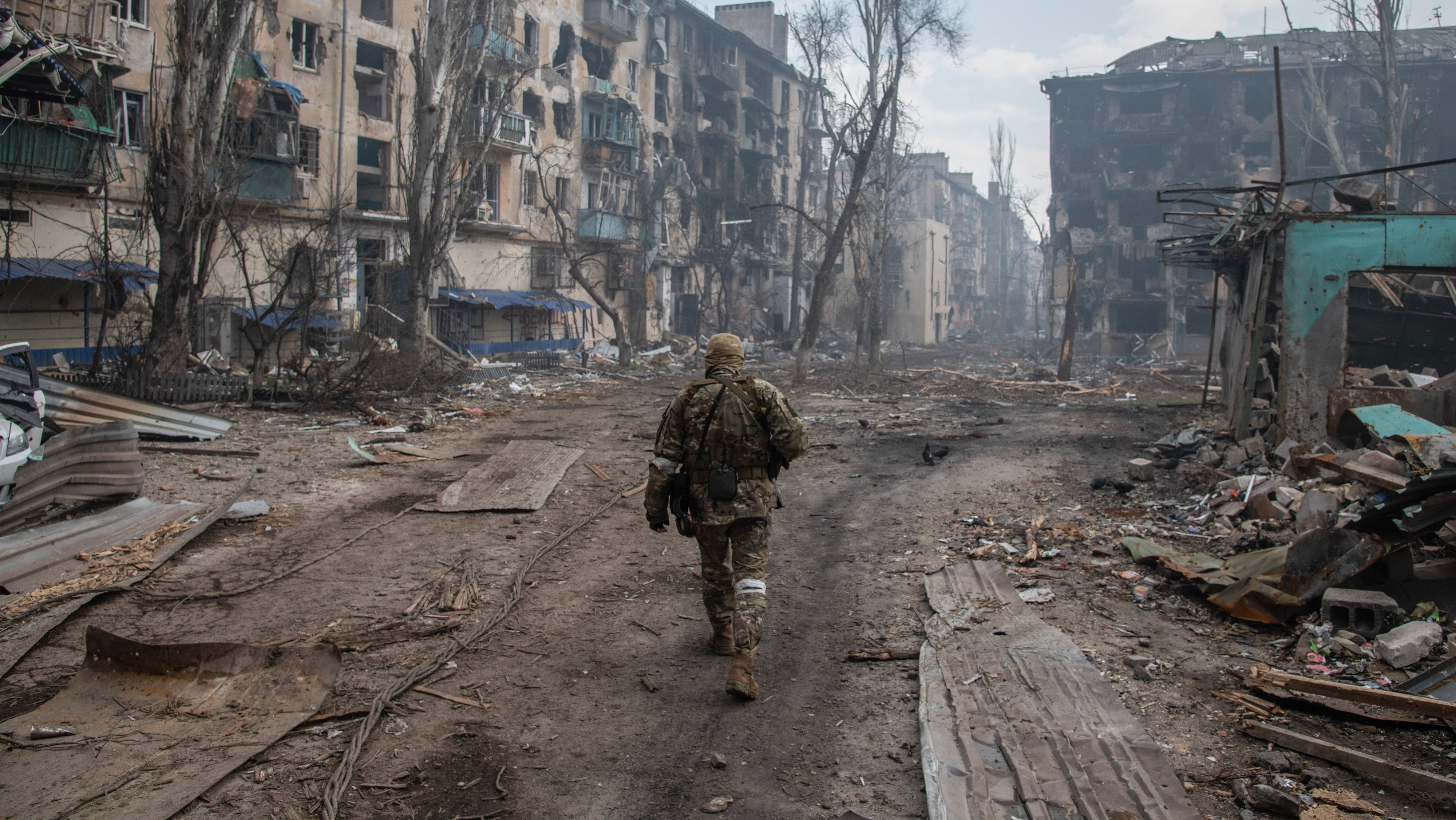 A Russian soldier walks amidst the rubble in Mariupol&#039;s