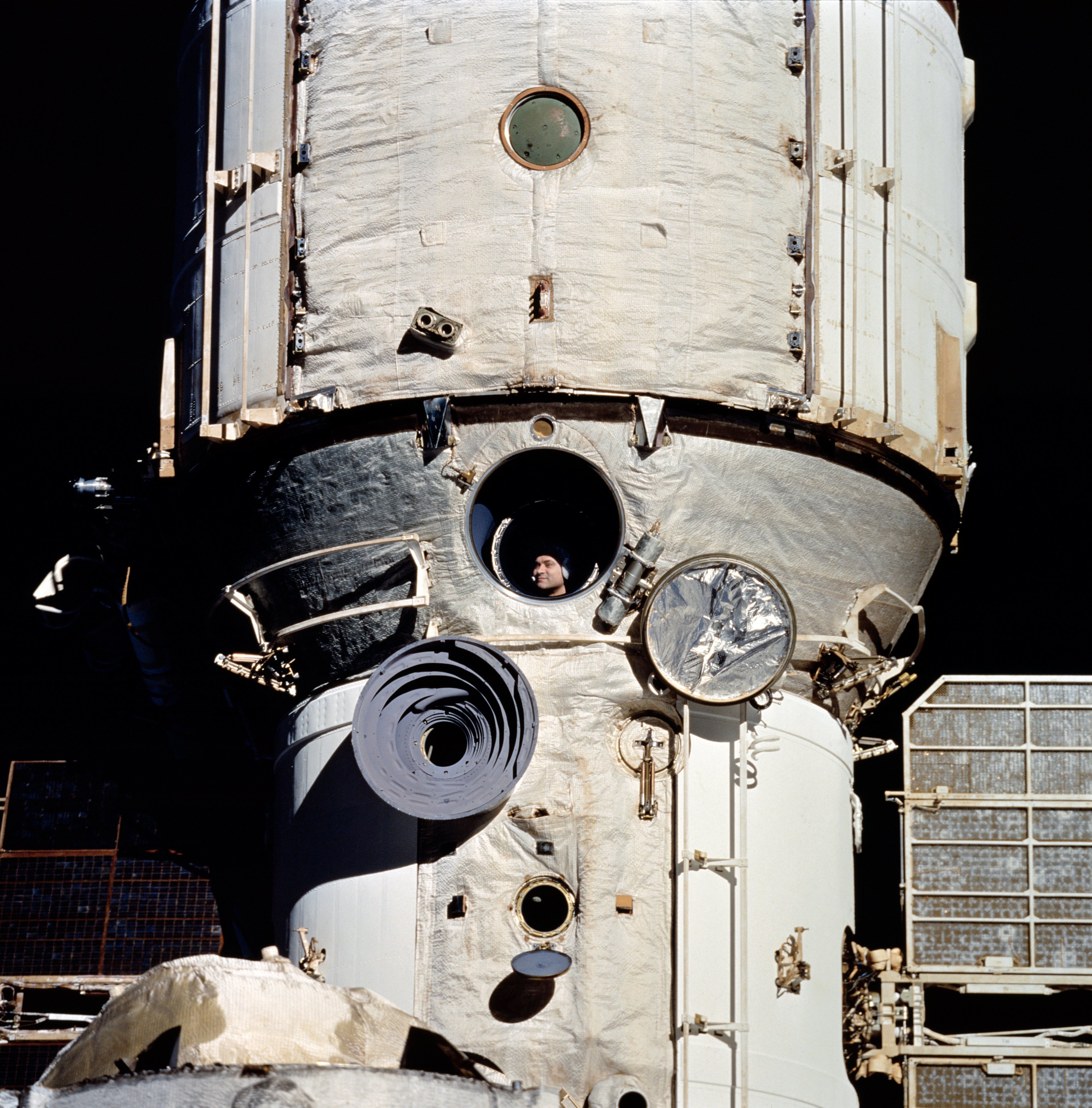 À janela da estação espacial Mir, o cosmonauta Valeri Polyakov aguarda o encontro com a nave espacial norte-americana Discovery