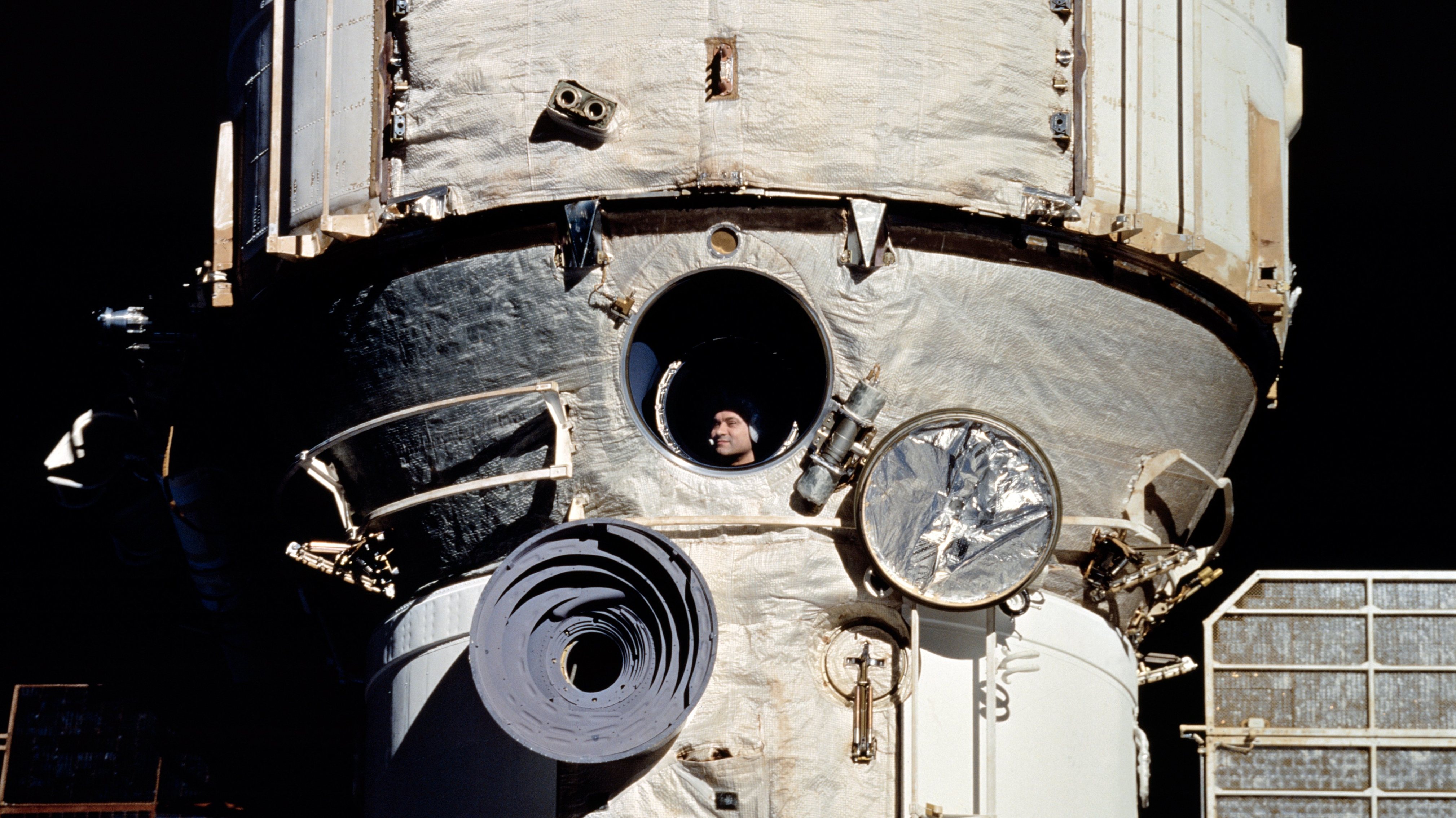 À janela da estação espacial Mir, o cosmonauta Valeri Polyakov aguarda o encontro com a nave espacial norte-americana Discovery
