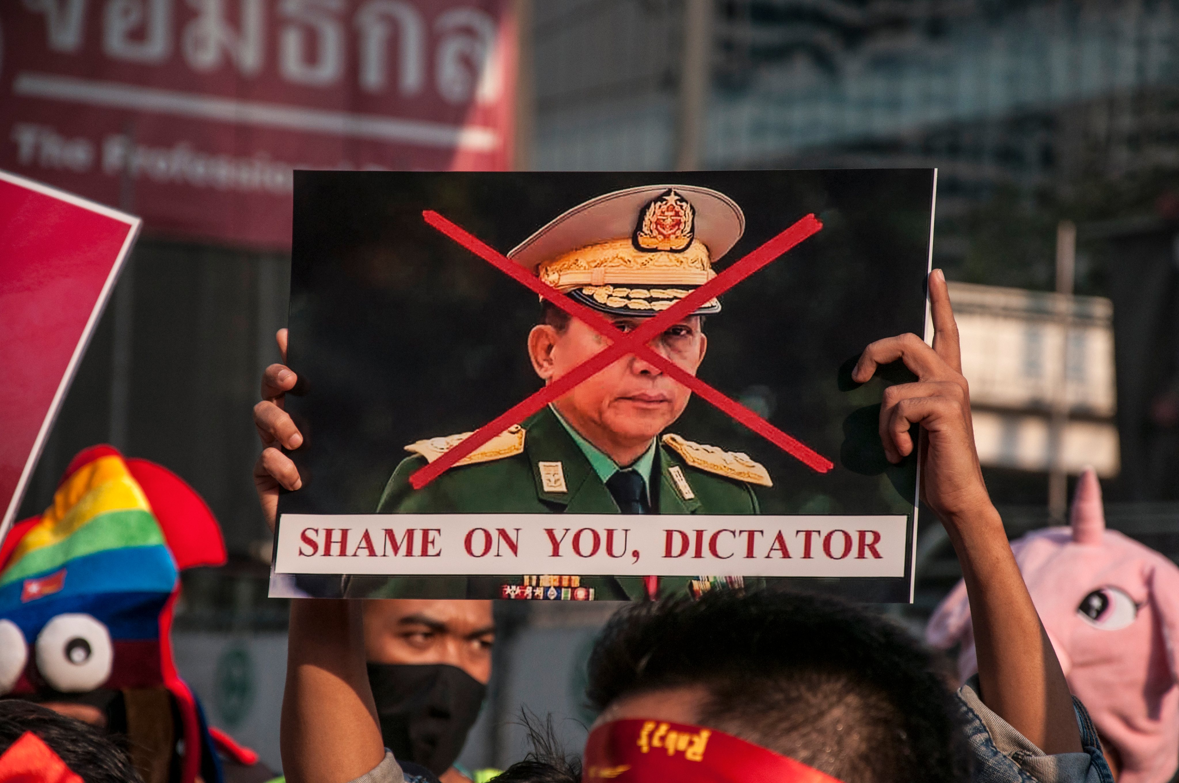 NLD supporter holds a crossed-out portrait of Myanmar&#039;s army