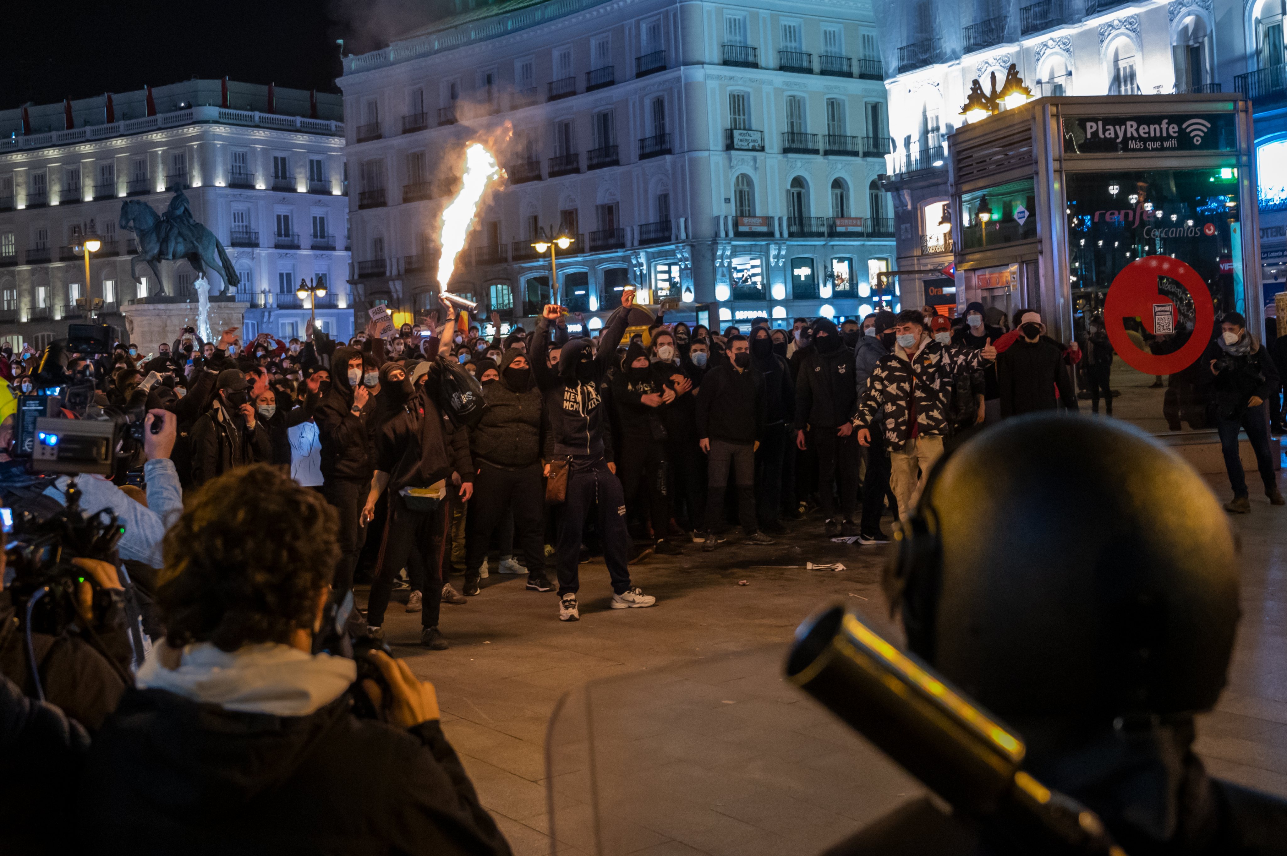 A protester burning a blowtorch facing police during a