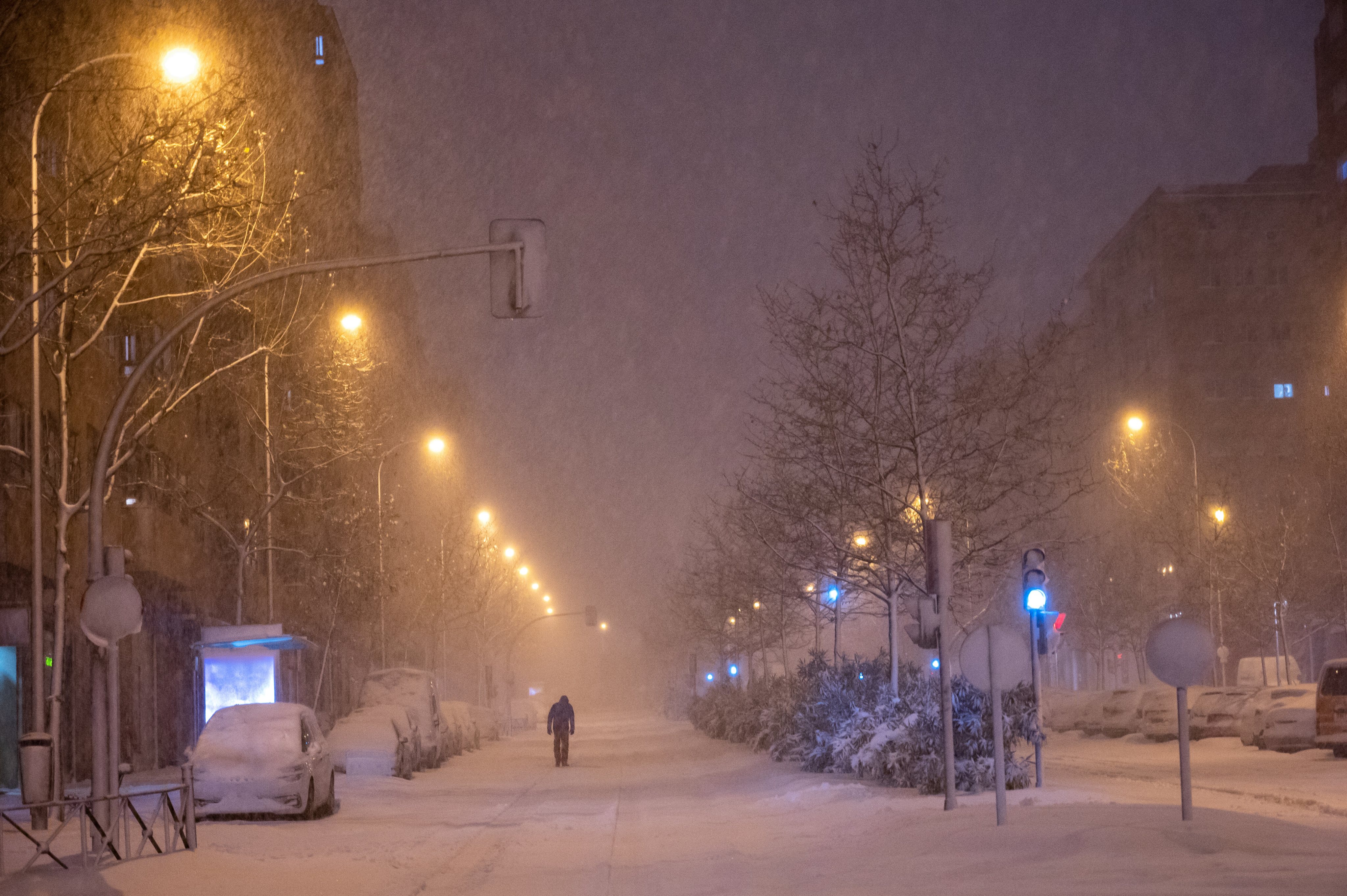 A man walking as snow falls in Madrid. Heavy snow is falling