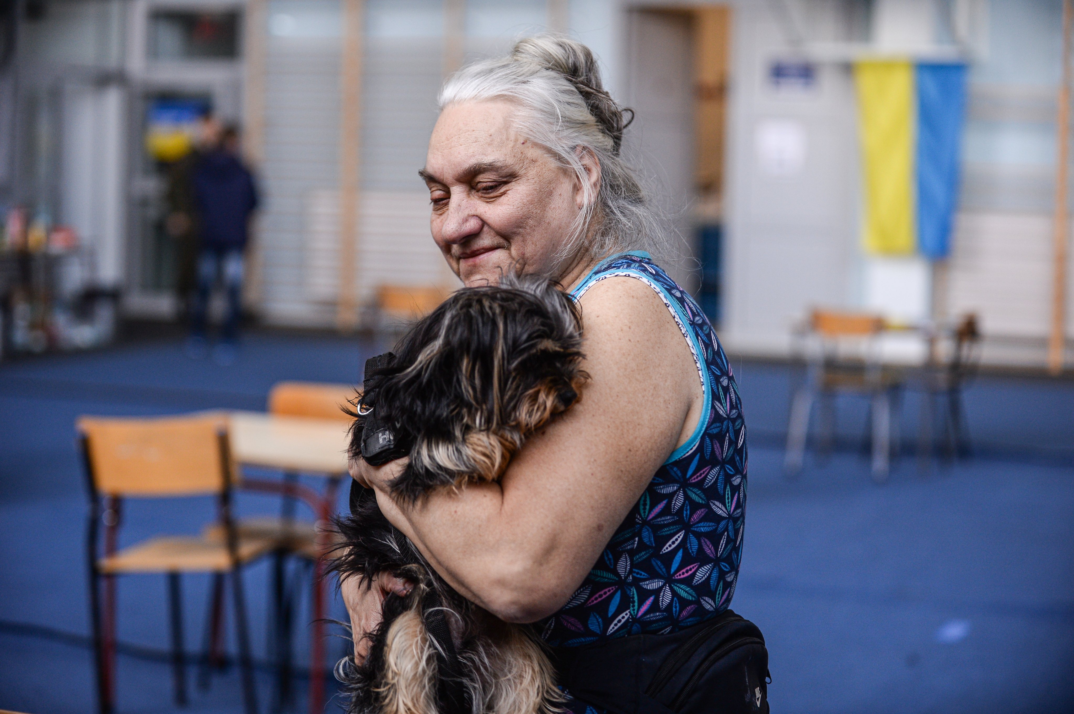 Uma mulher abraça o seu cão num refúgio temporário na Polónia