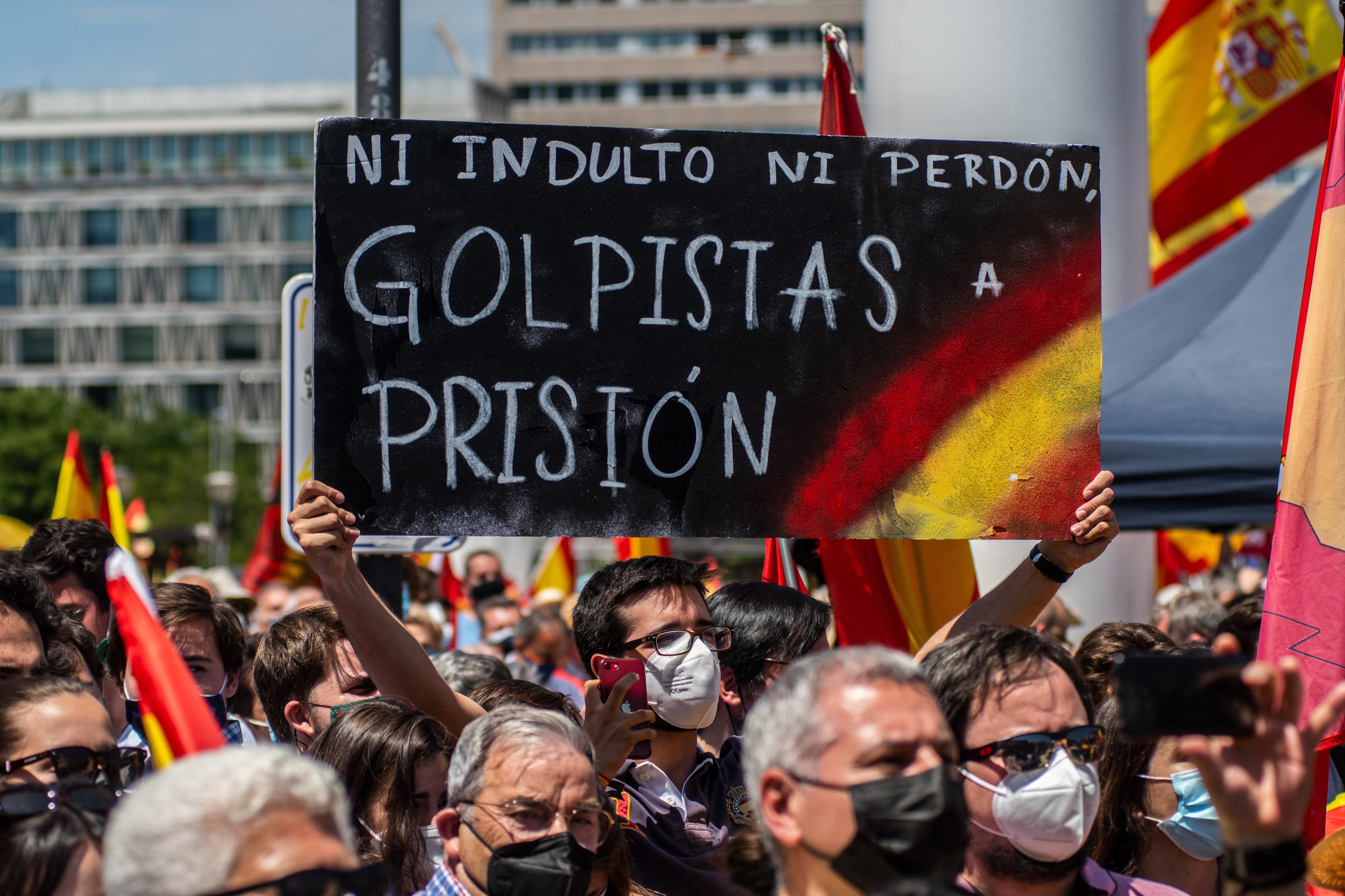 Protesters carrying placards and Spanish flags during a