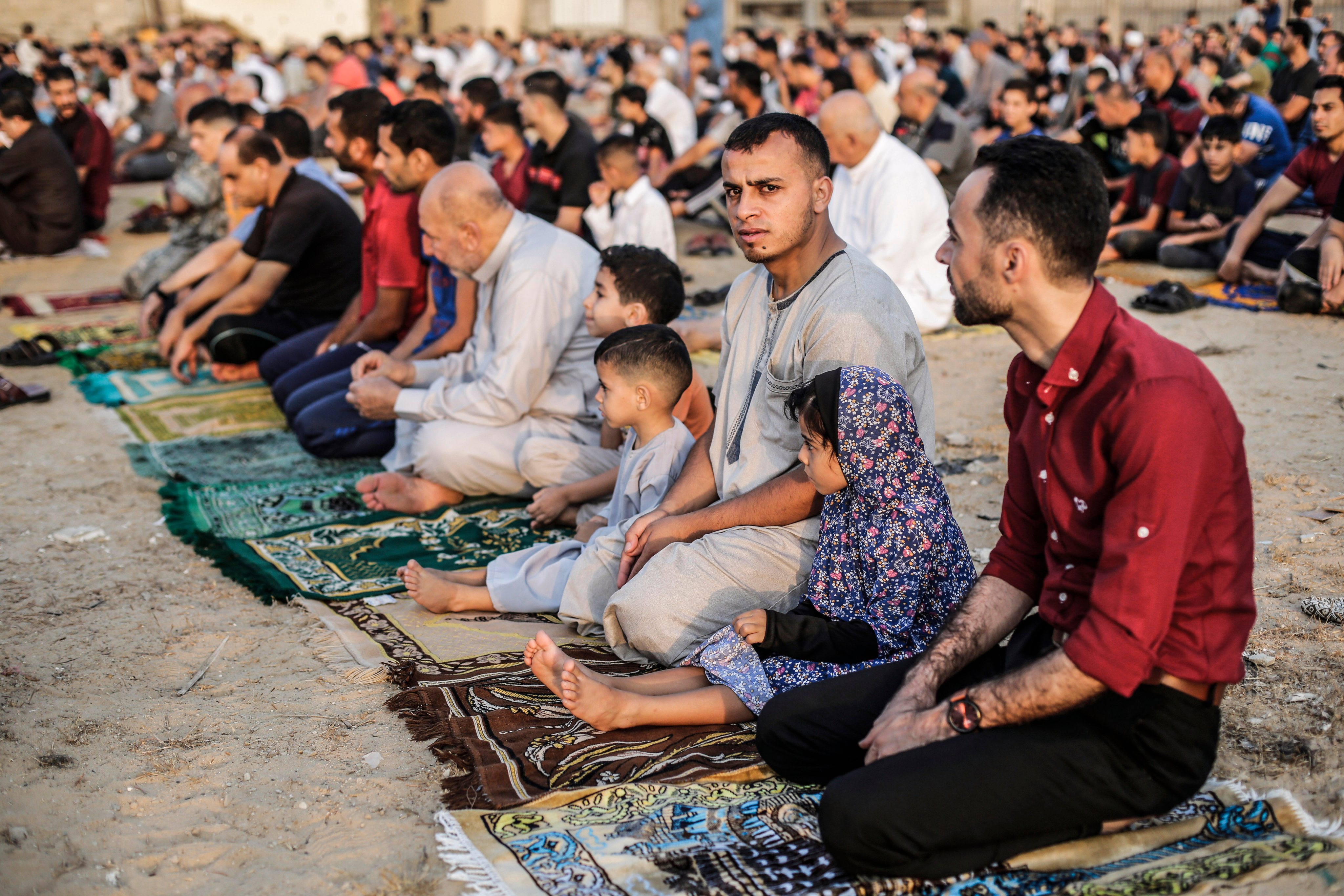 Palestinian Muslims perform prayers in a square, on the