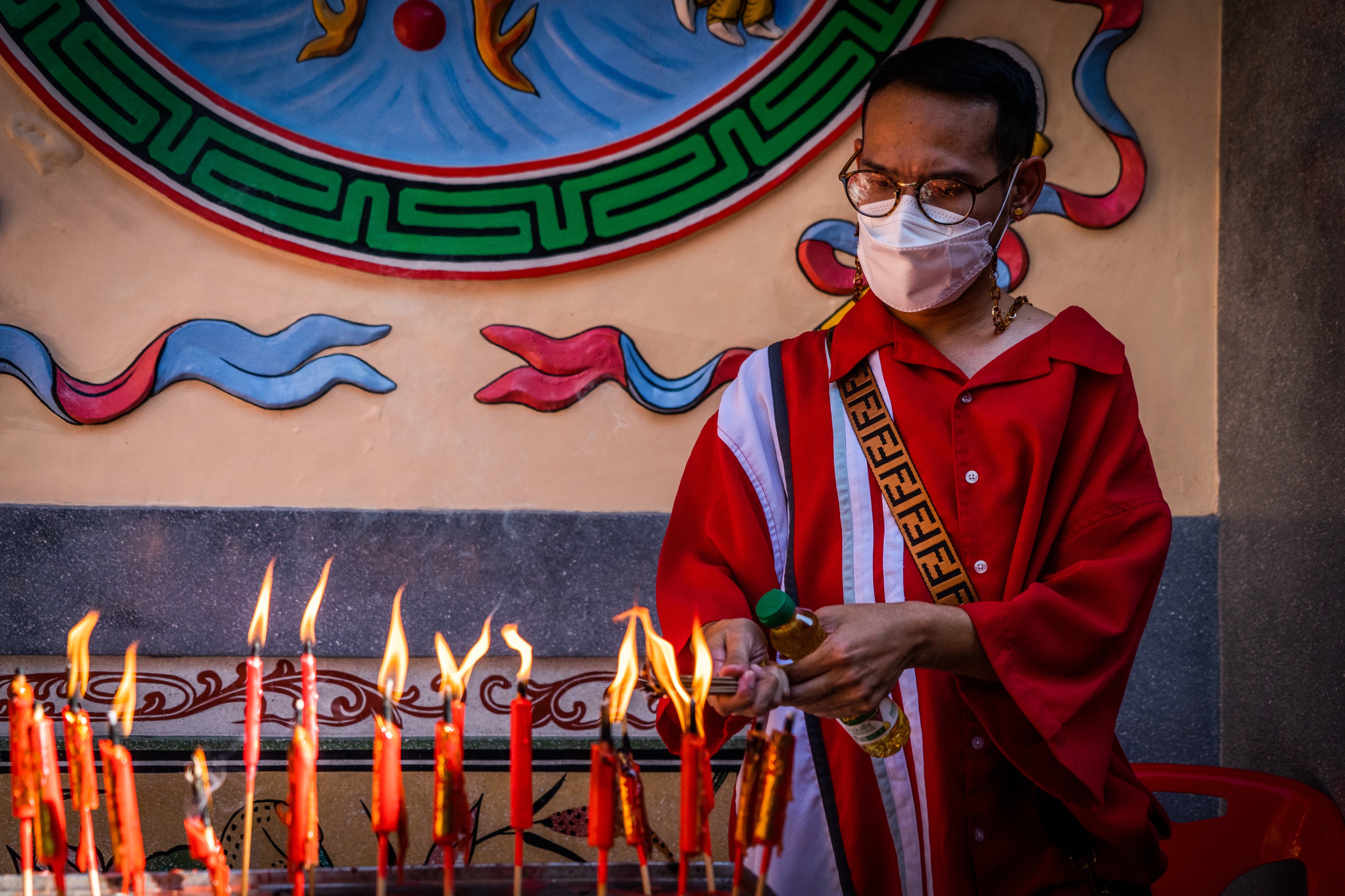 A man lights candles at a temple in Bangkok&#039;s Chinatown on