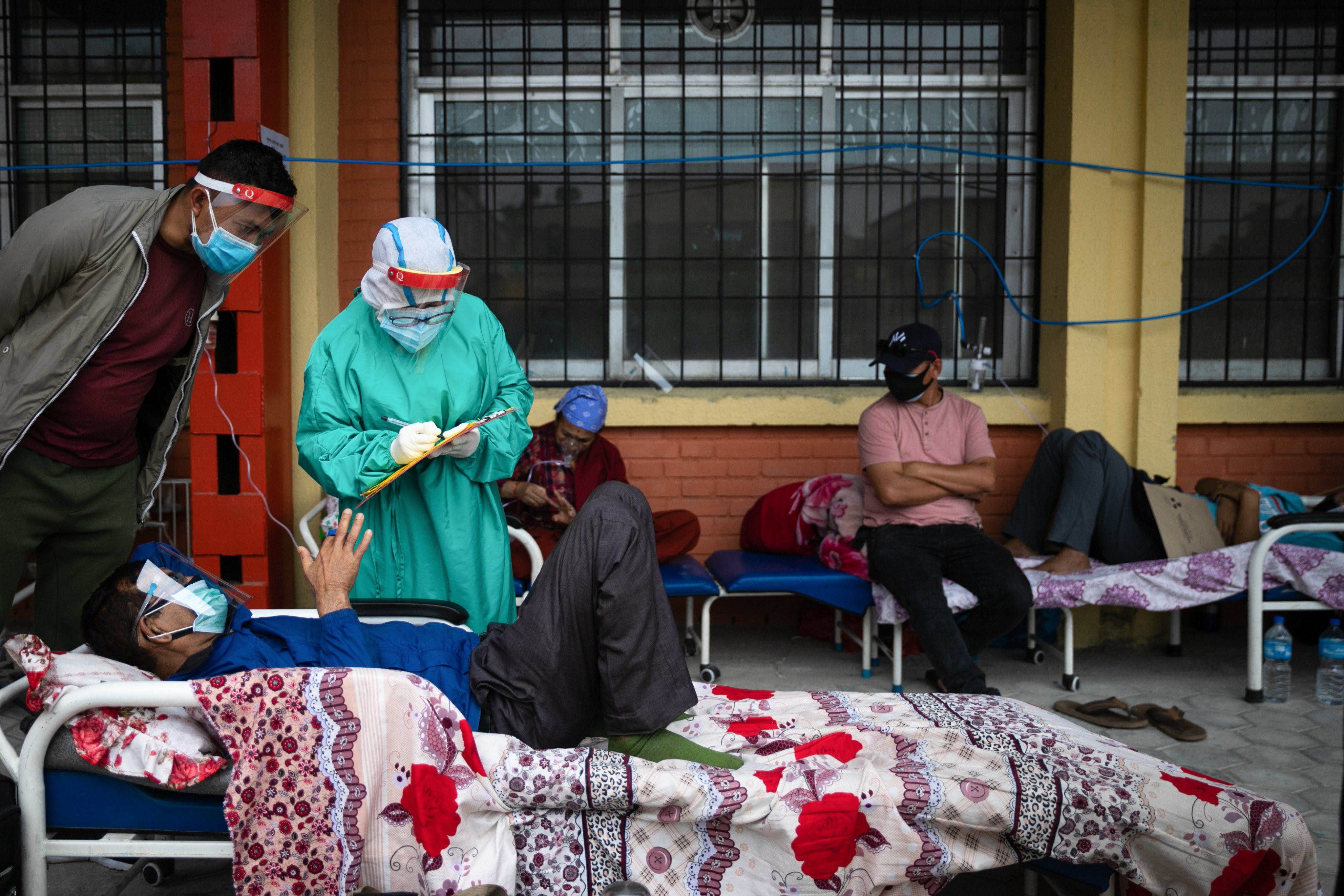 Nepalese health worker attends to a COVID-19 patient outside