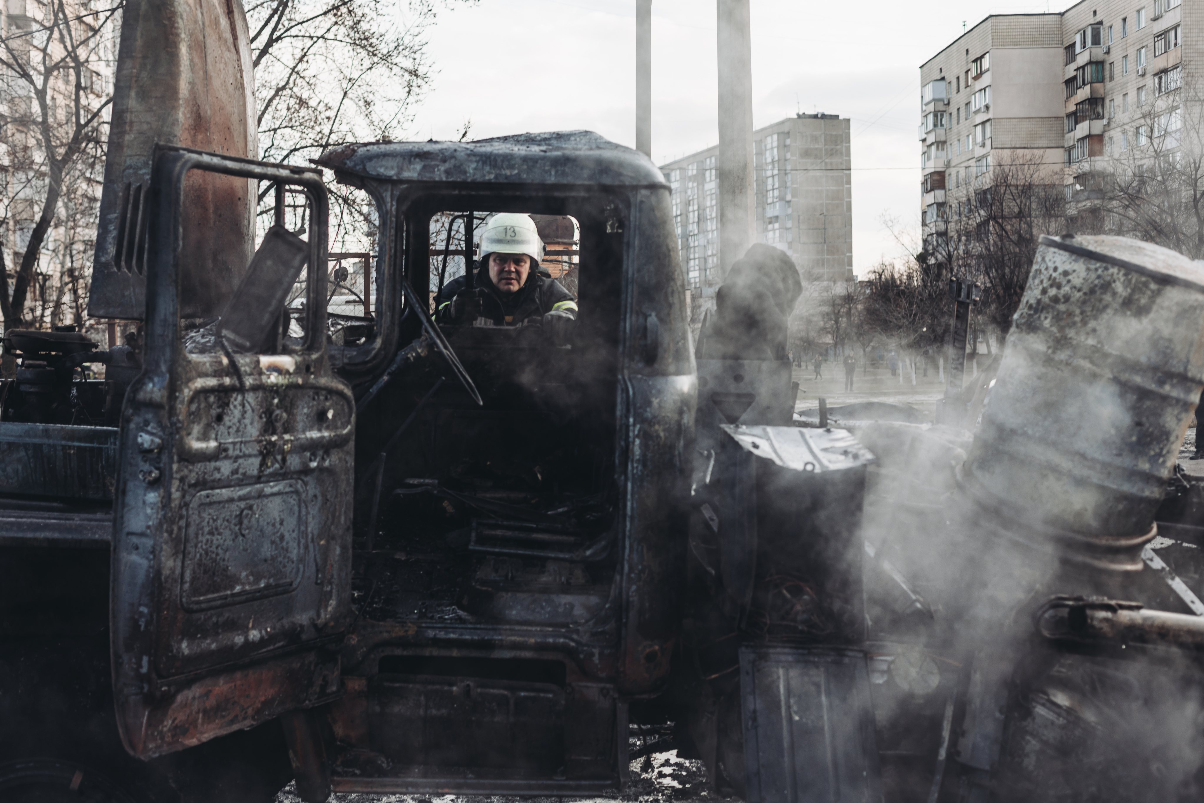 Um bombeiro junto de um veículo militar queimado em Kiev