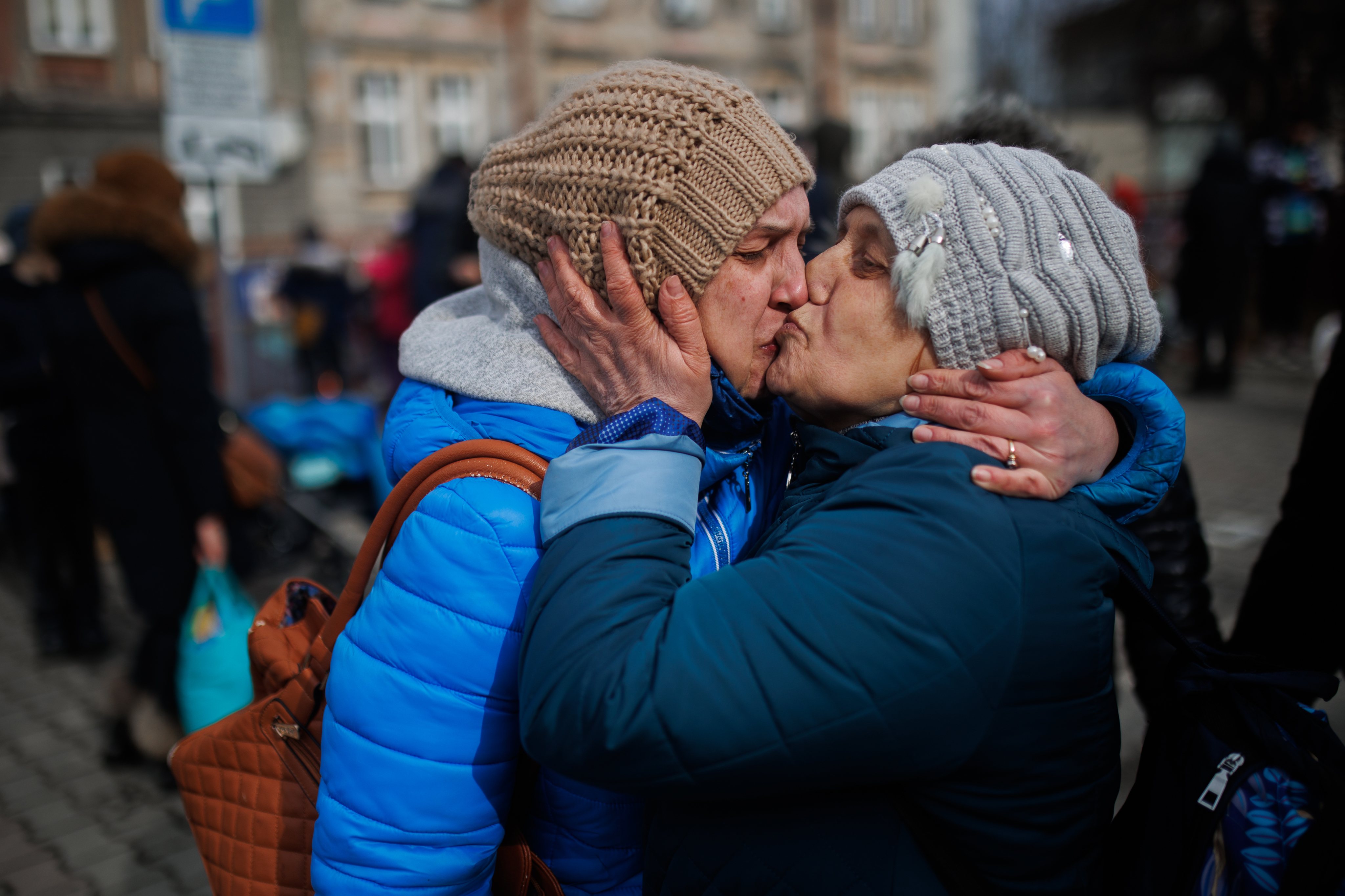 Uma mãe e um filha beijam-se na chegada à Polónia