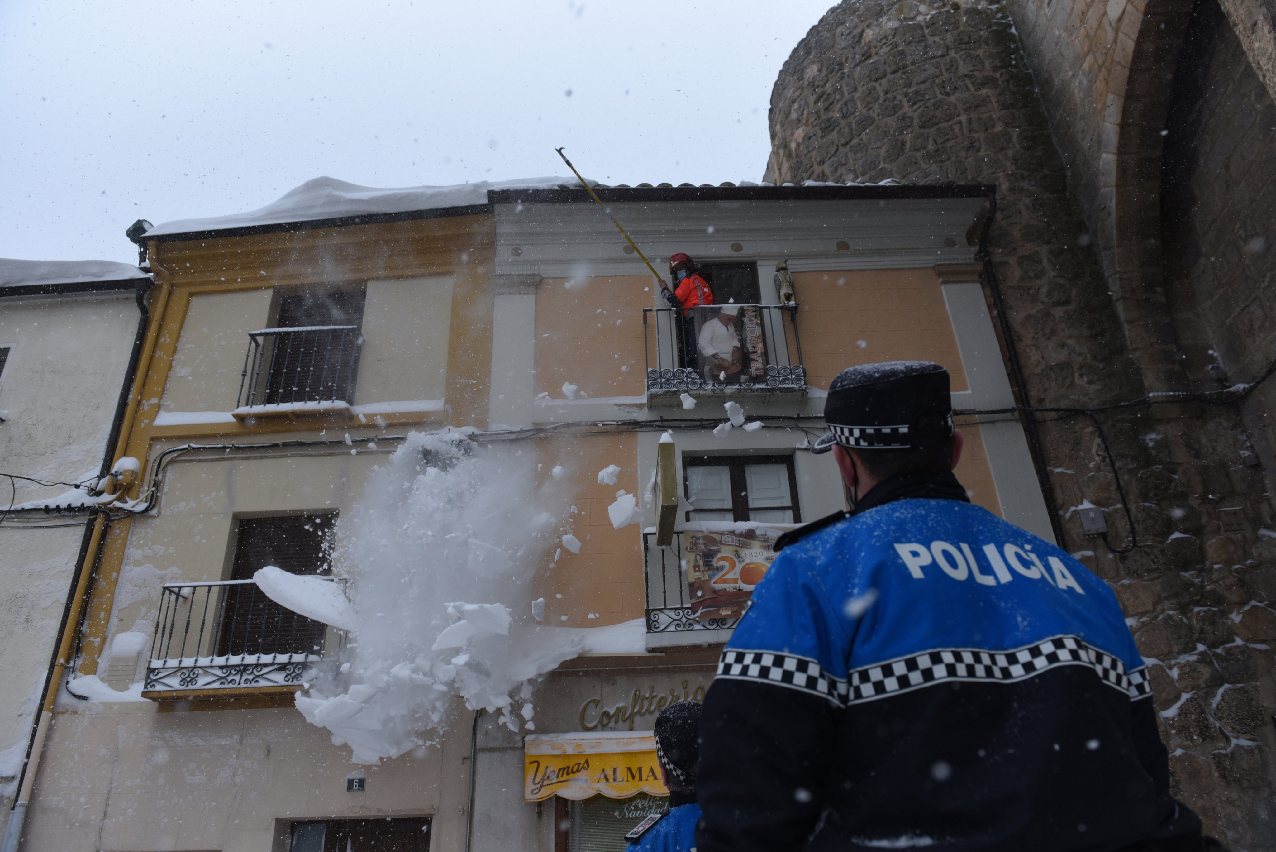 A firefighter cleans snow from a roof during the Filomena