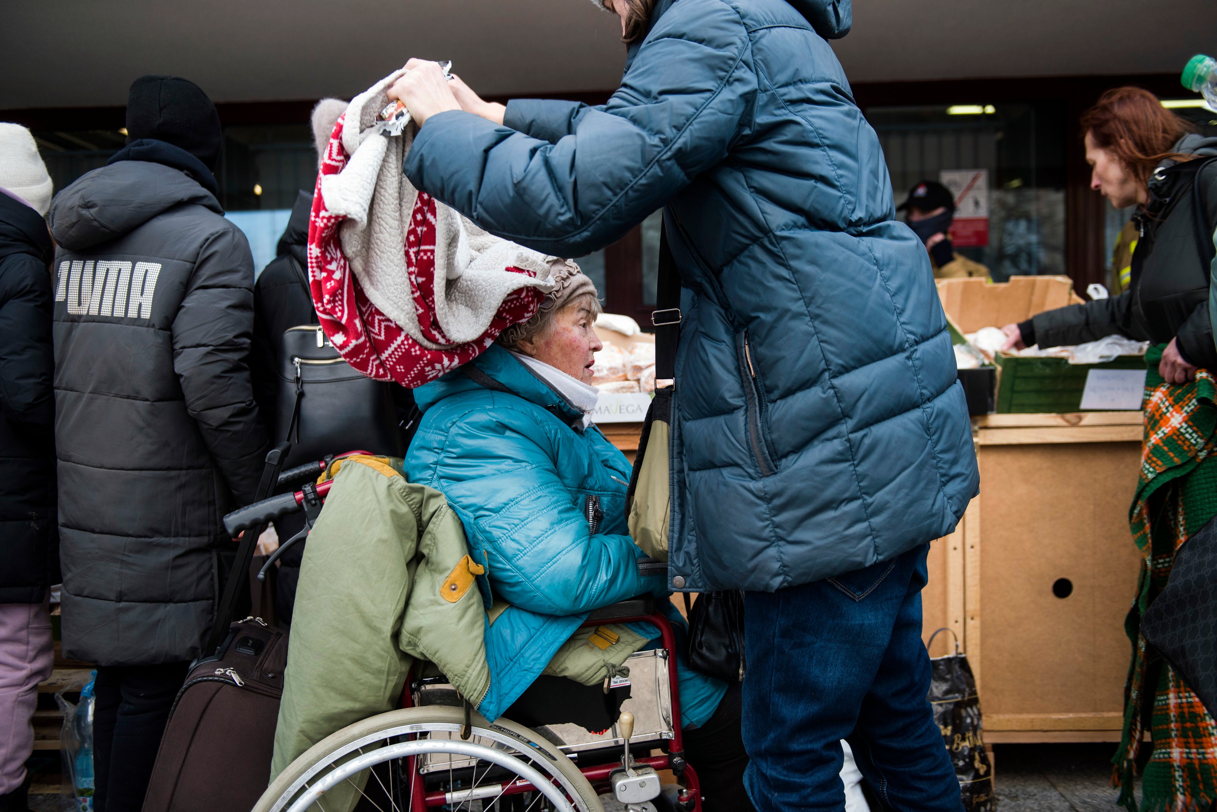 Um homem cobre uma mulher ucraniana na sua chegada à Polónia