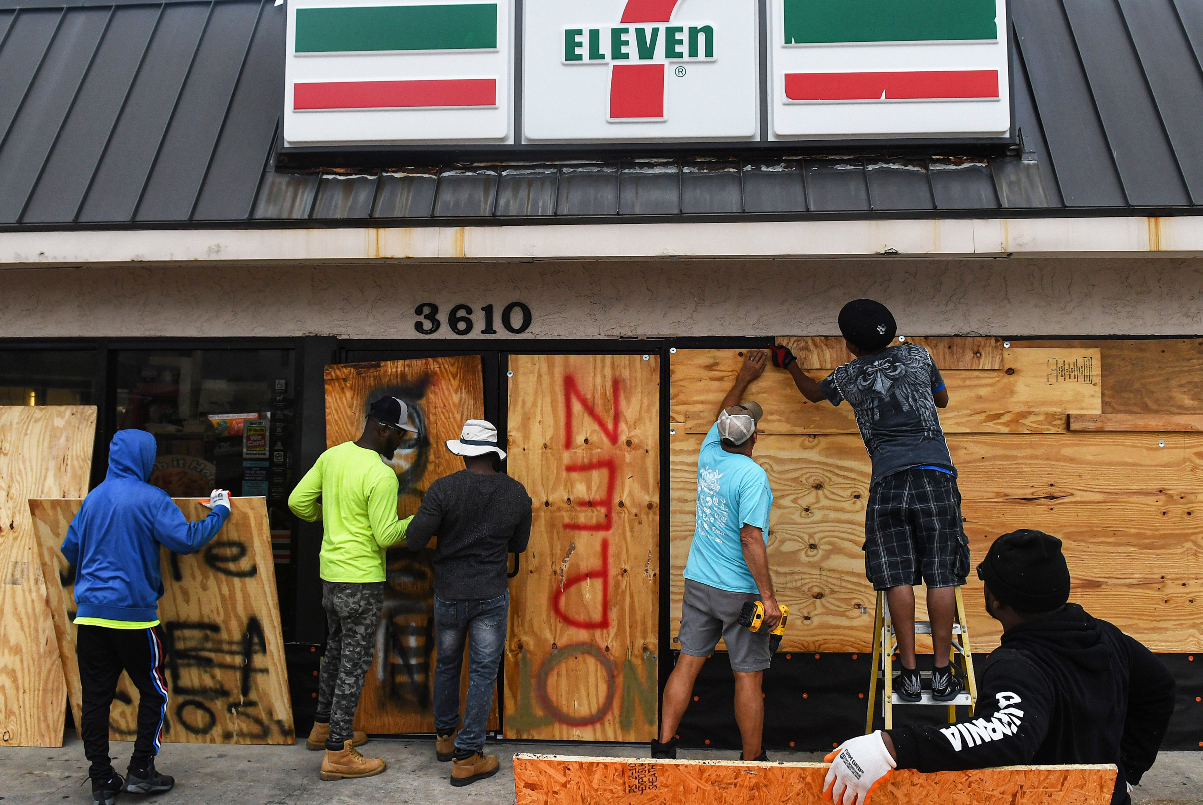 Workers board up a store with plywood in Daytona Beach
