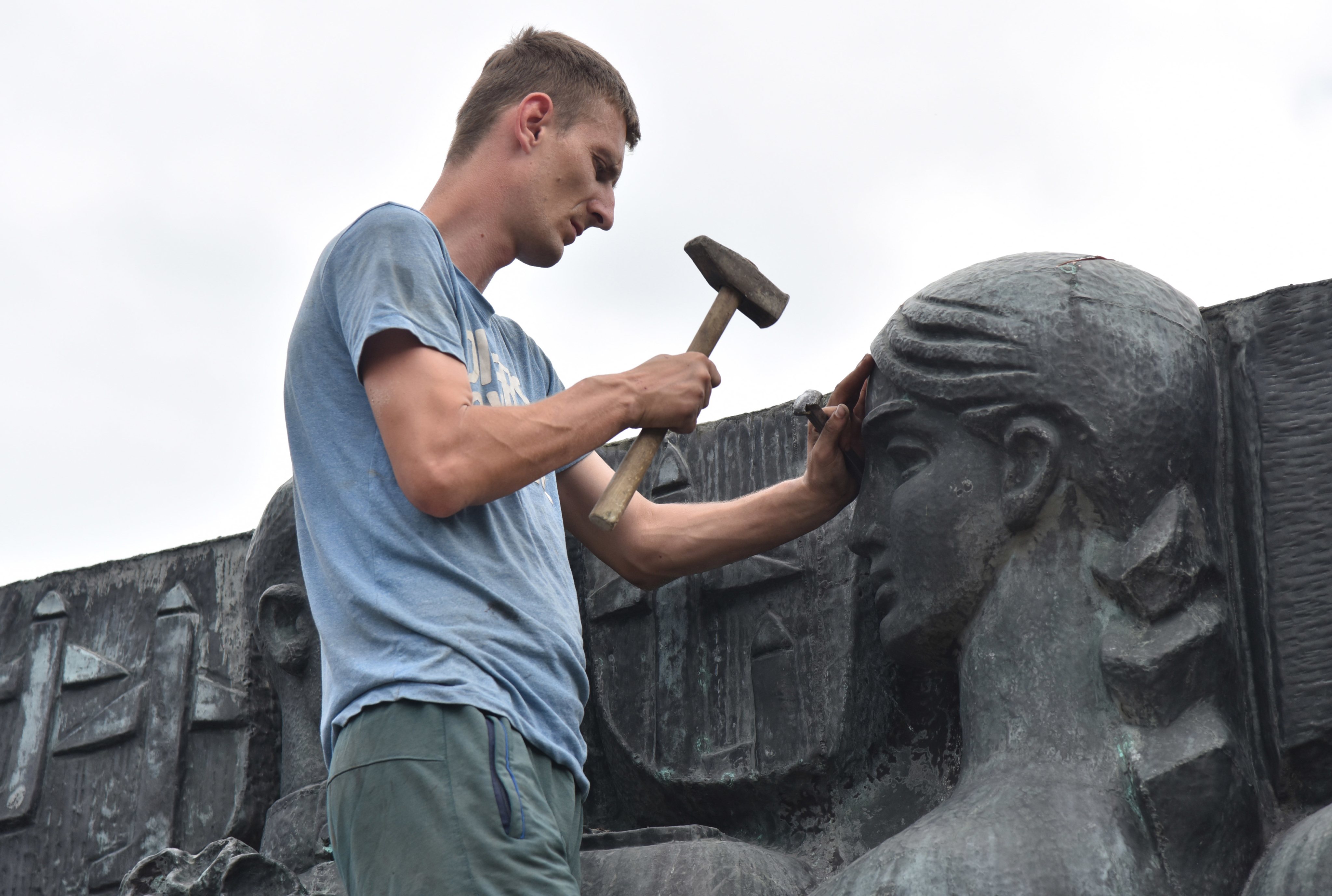 A worker separates part of the bas-relief on the Monument of