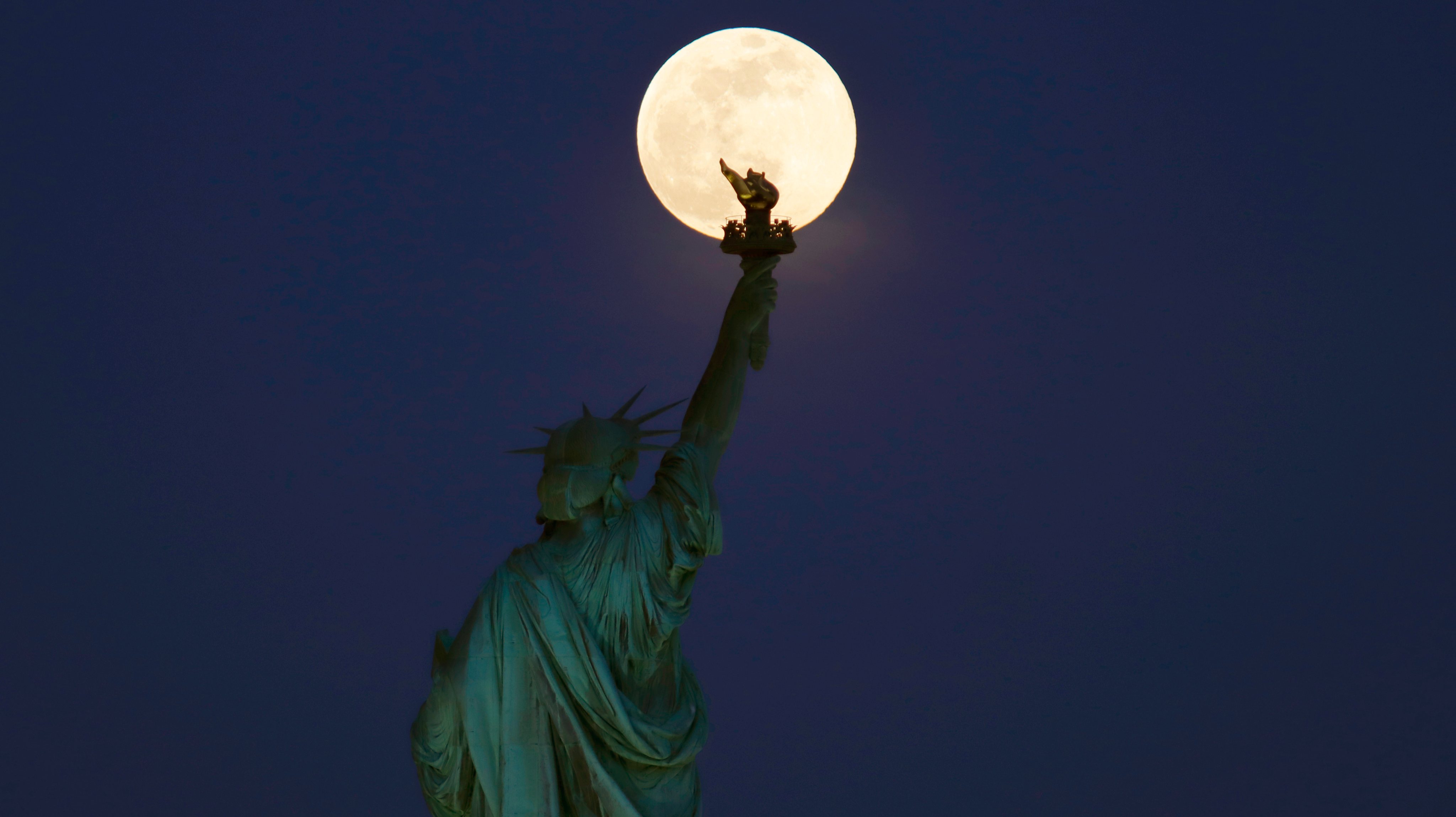 Super Pink Moon Rises Above the Statue of Liberty in New York City
